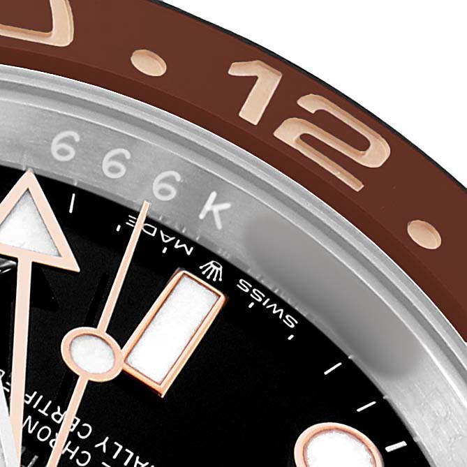 This close-up image of a Rolex GMT-Master 126711 Men's Steel and Gold (two tone) Black Dial shows part of the brown bezel, the dial, and the hands.
