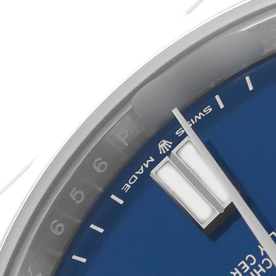 The image shows a close-up of the Oyster Perpetual Rolex watch, highlighting the blue dial, markers, and part of the bezel.
