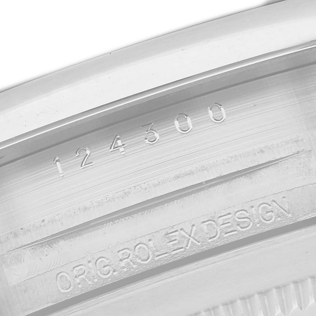 The image shows the inner bezel of a Rolex Oyster Perpetual 124300 Men
s Stainless Steel Blue Dial 124300 Men
s Stainless Steel Blue Dial with the model number and "ORIG ROLEX DESIGN" engraving.