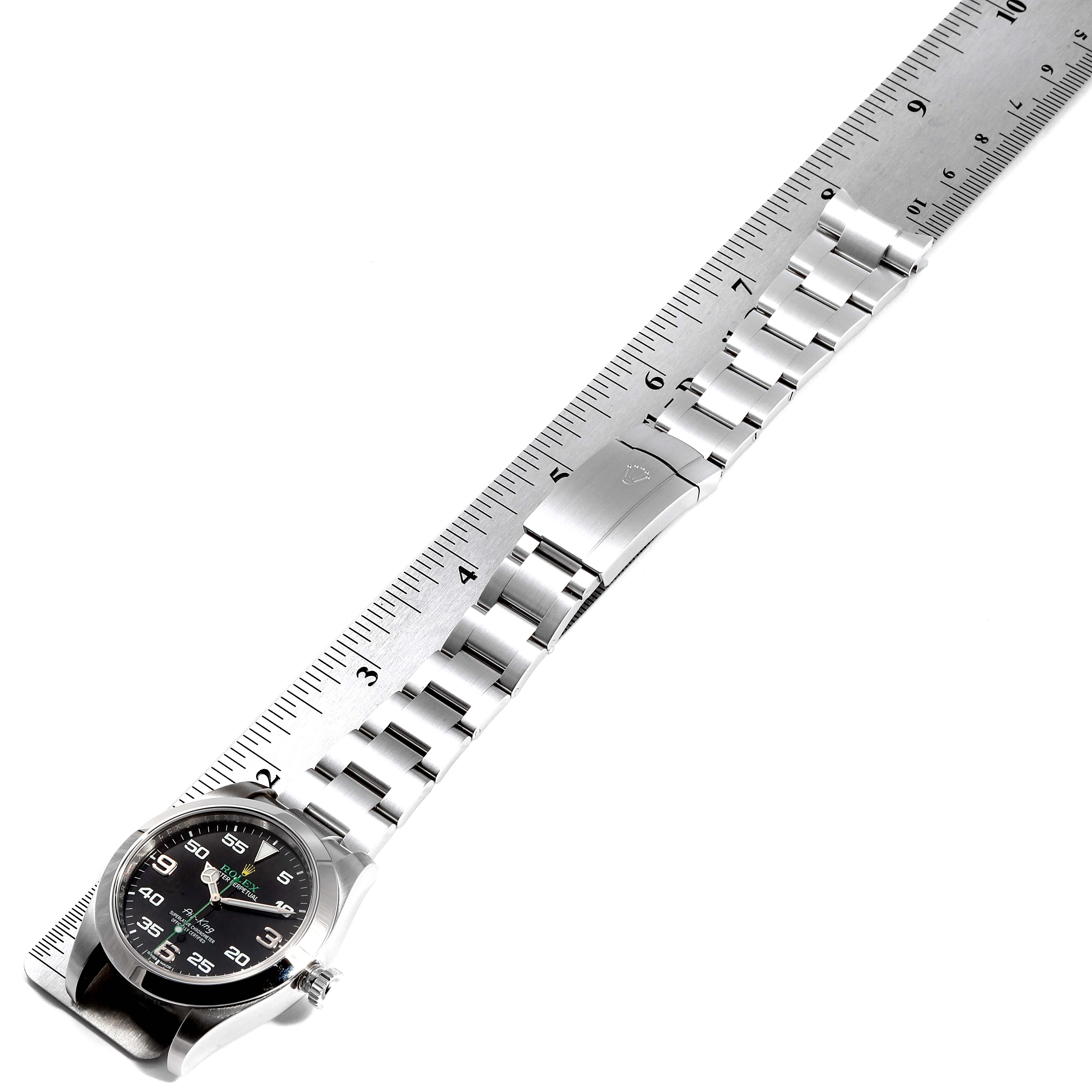 The image shows a Rolex Air-King 116900 Men's Stainless Steel Black Dial 116900 Men's Stainless Steel Black Dial watch laid flat next to a ruler, displaying the dial, bracelet, and clasp.