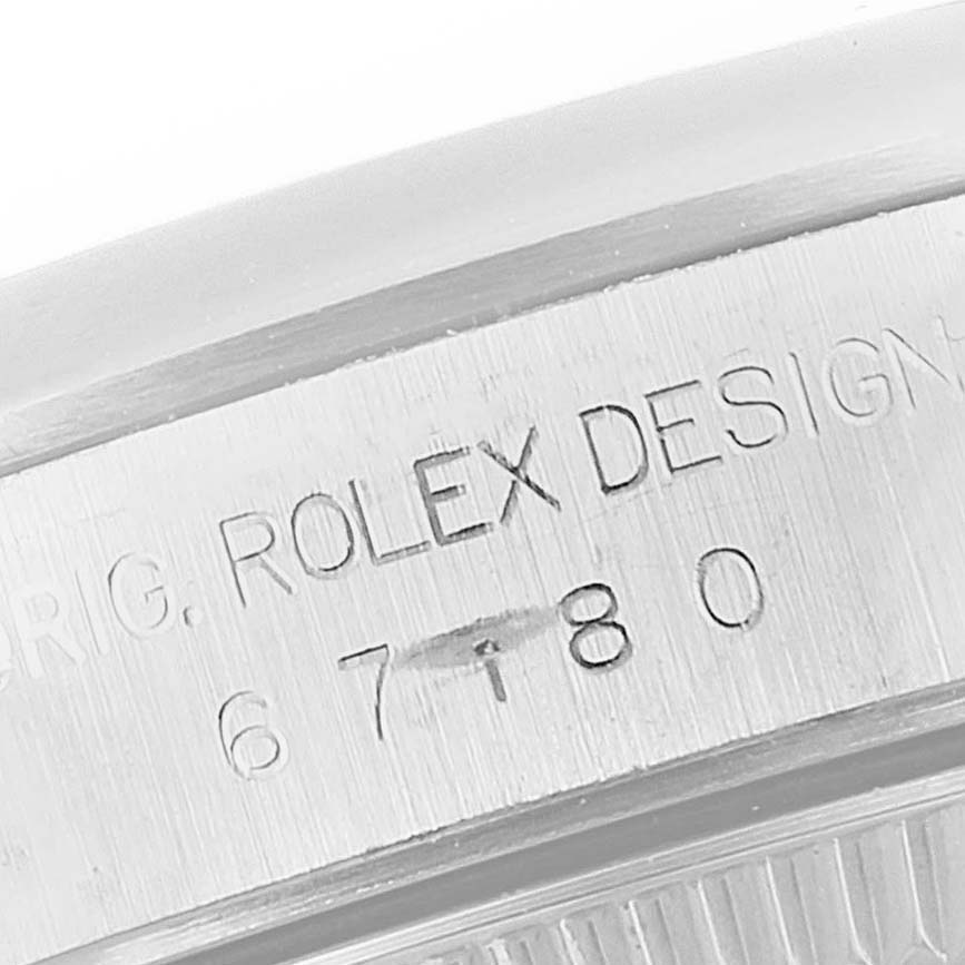 This image shows the side view of the Rolex Oyster Perpetual 67180 Women's Stainless Steel Pink Dial 67180 Women's Stainless Steel Pink Dial watch, displaying its engraved serial number and "ROLEX DESIGN".