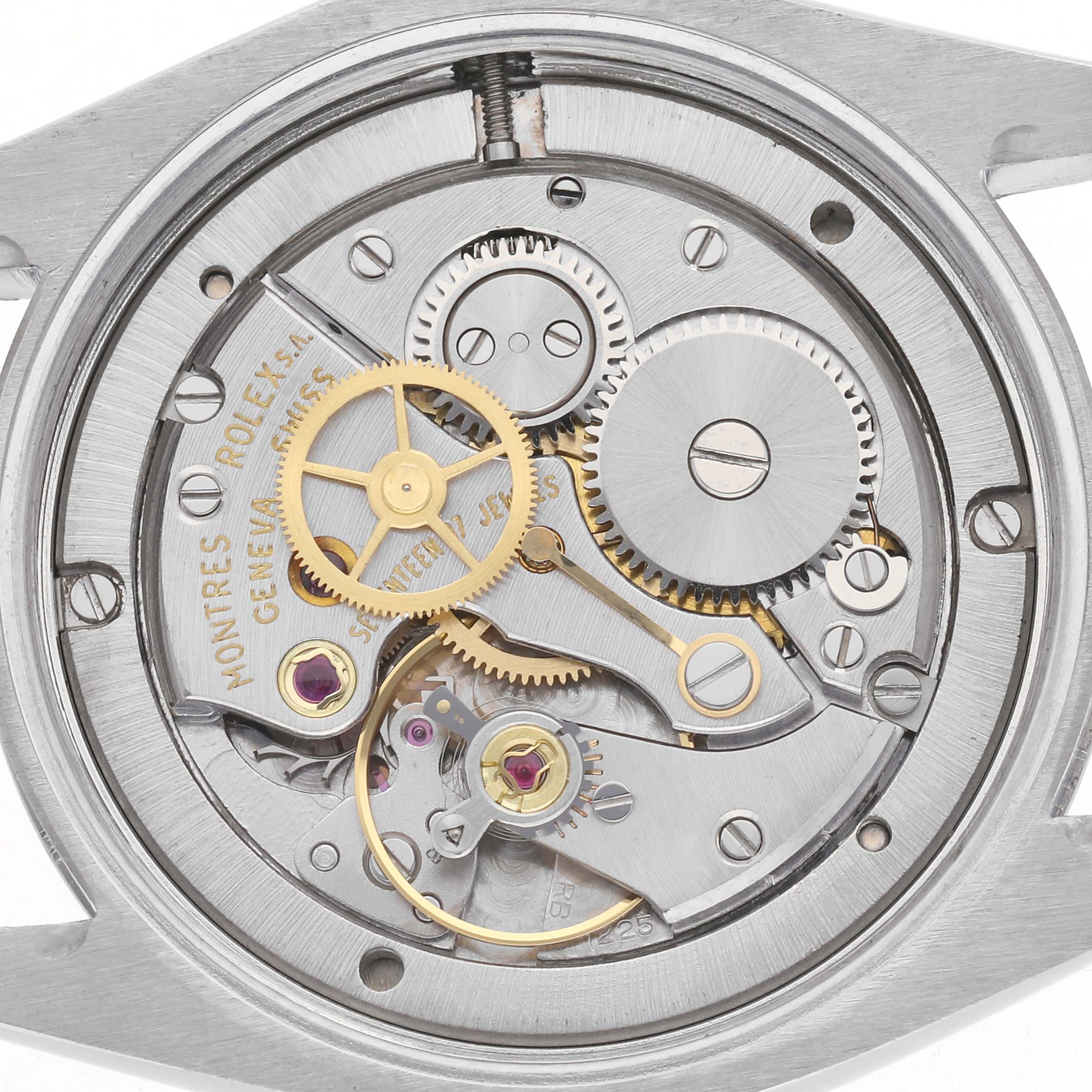 The image shows a close-up view of the movement inside a Rolex Date 6694 Men
s Stainless Steel Silver Dial 6694 Men
s Stainless Steel Silver Dial model watch, displaying gears and mechanical parts.