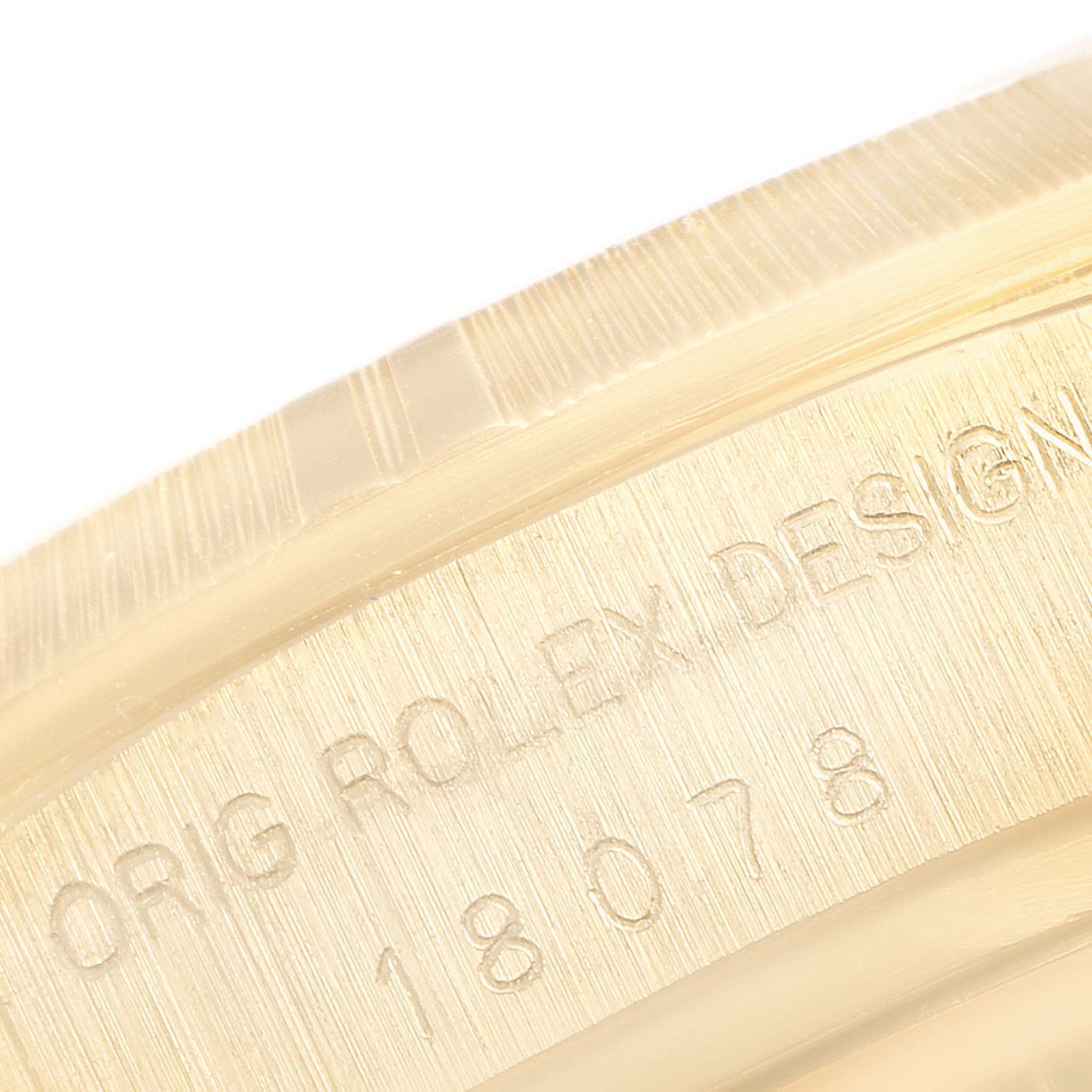 This close-up image of a Rolex President 18078 Men's Yellow Gold Blue Dial 18078 Men's Yellow Gold Blue Dial model watch shows part of the case with engraved text and serial numbers.