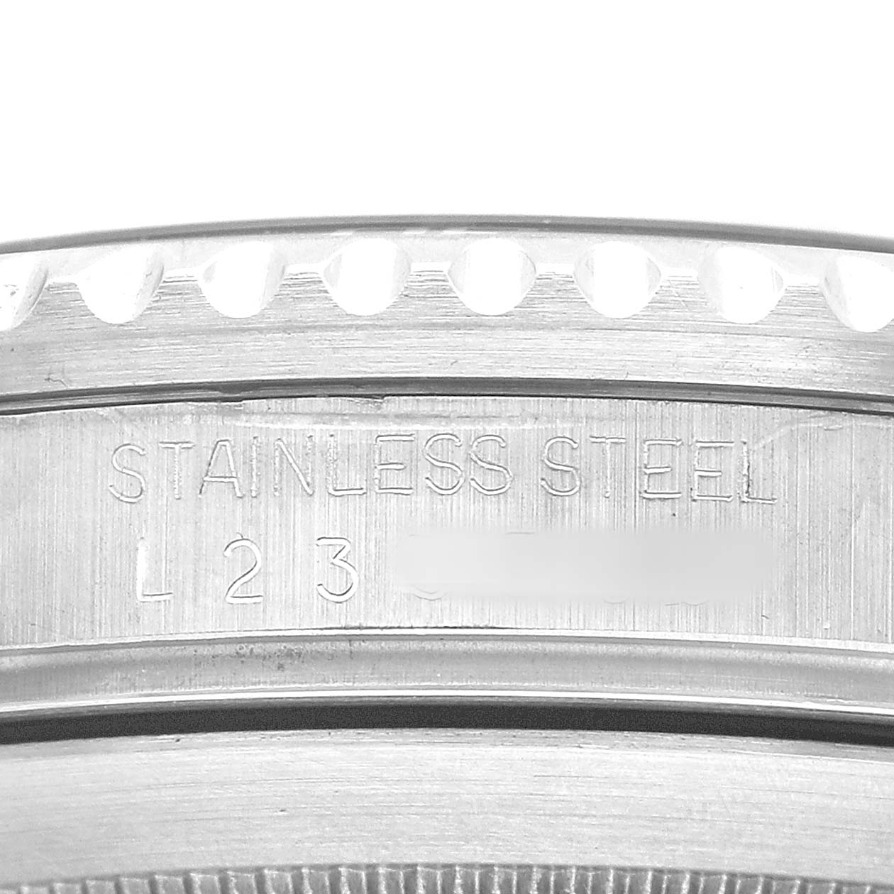 The image shows a close-up of the side casing of a Rolex Submariner 16610 Men's Stainless Steel Black Dial, highlighting the "STAINLESS STEEL" engraving.