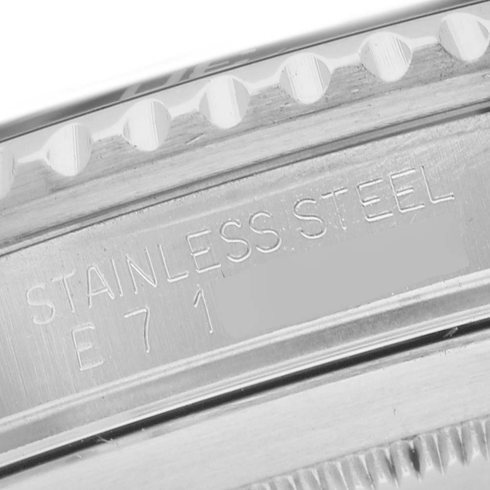 The image shows a close-up of the case side engraving and bezel edge of a Rolex Submariner 16610 Men's Stainless Steel Black Dial, highlighting "STAINLESS STEEL" text.