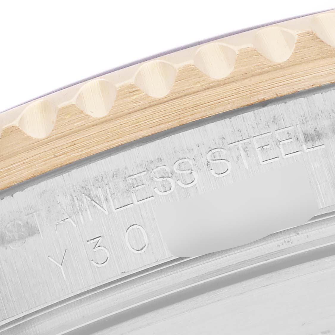 The image shows a close-up of the edge of a Rolex Submariner 16613 Men
s Steel and Gold (two tone) Blue Dial 16613 Men
s Steel and Gold (two tone) Blue Dial, highlighting the stainless steel and part of the bezel.