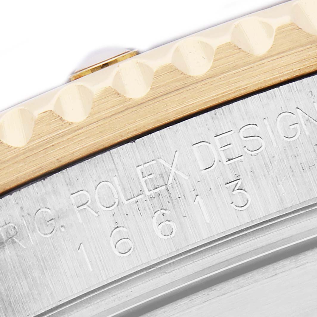 The image shows a close-up of the Rolex Submariner 16613 Men
s Steel and Gold (two tone) Blue Dial 16613 Men
s Steel and Gold (two tone) Blue Dial
s case and bezel, showcasing the design engraving.