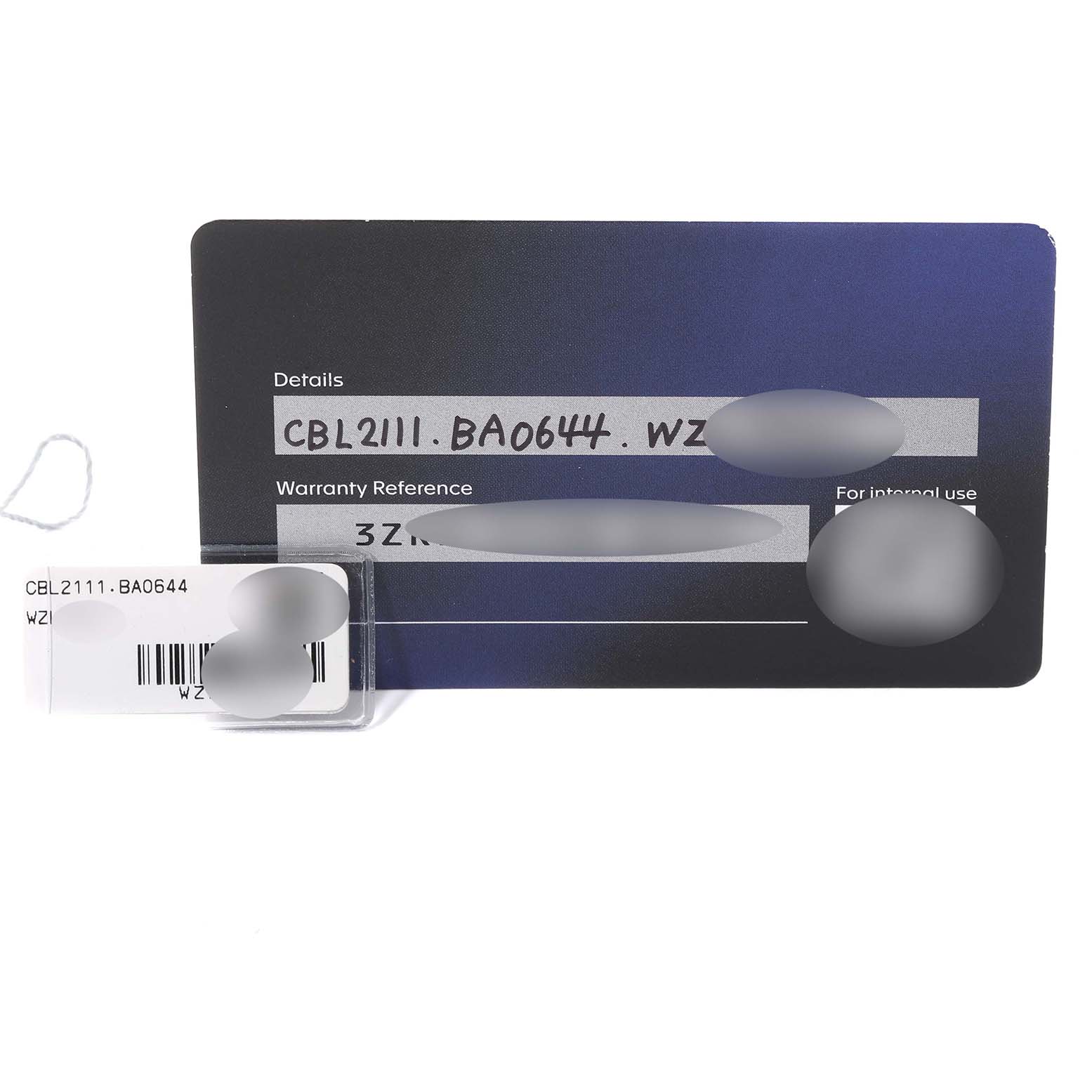 The image shows a Tag Heuer Monaco CBL2111.BA0644 Men
s Stainless Steel Blue Dial CBL2111.BA0644 Men
s Stainless Steel Blue Dial model warranty card and a small tag with the model number.