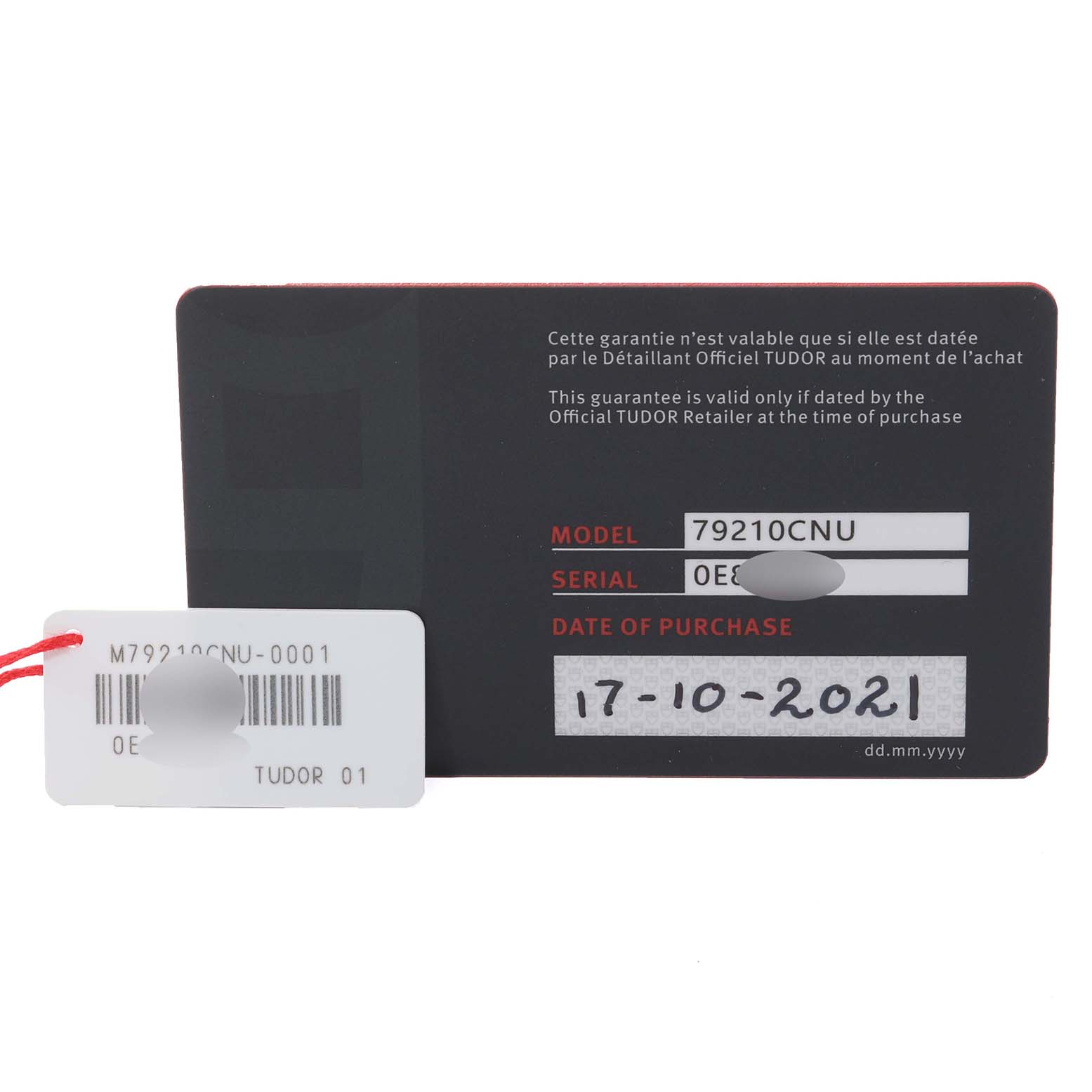 The image shows the warranty card and a tag for the Heritage Black Bay model by Tudor, displaying the model number, serial number, and date of purchase.