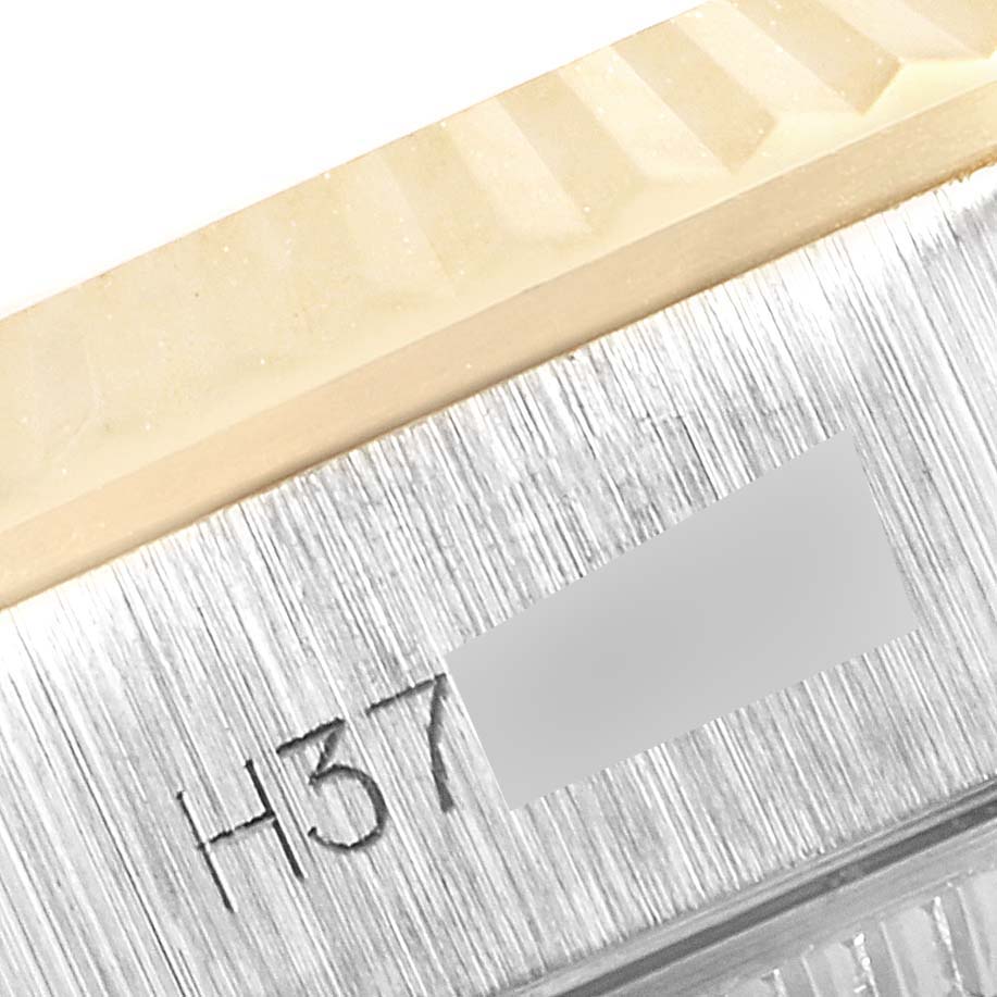 This close-up of a Tudor Princess 92513 Women's Steel and Gold (two tone) Silver Dial 92513 Women's Steel and Gold (two tone) Silver Dial watch shows part of the bezel and a portion of the engraved serial number.