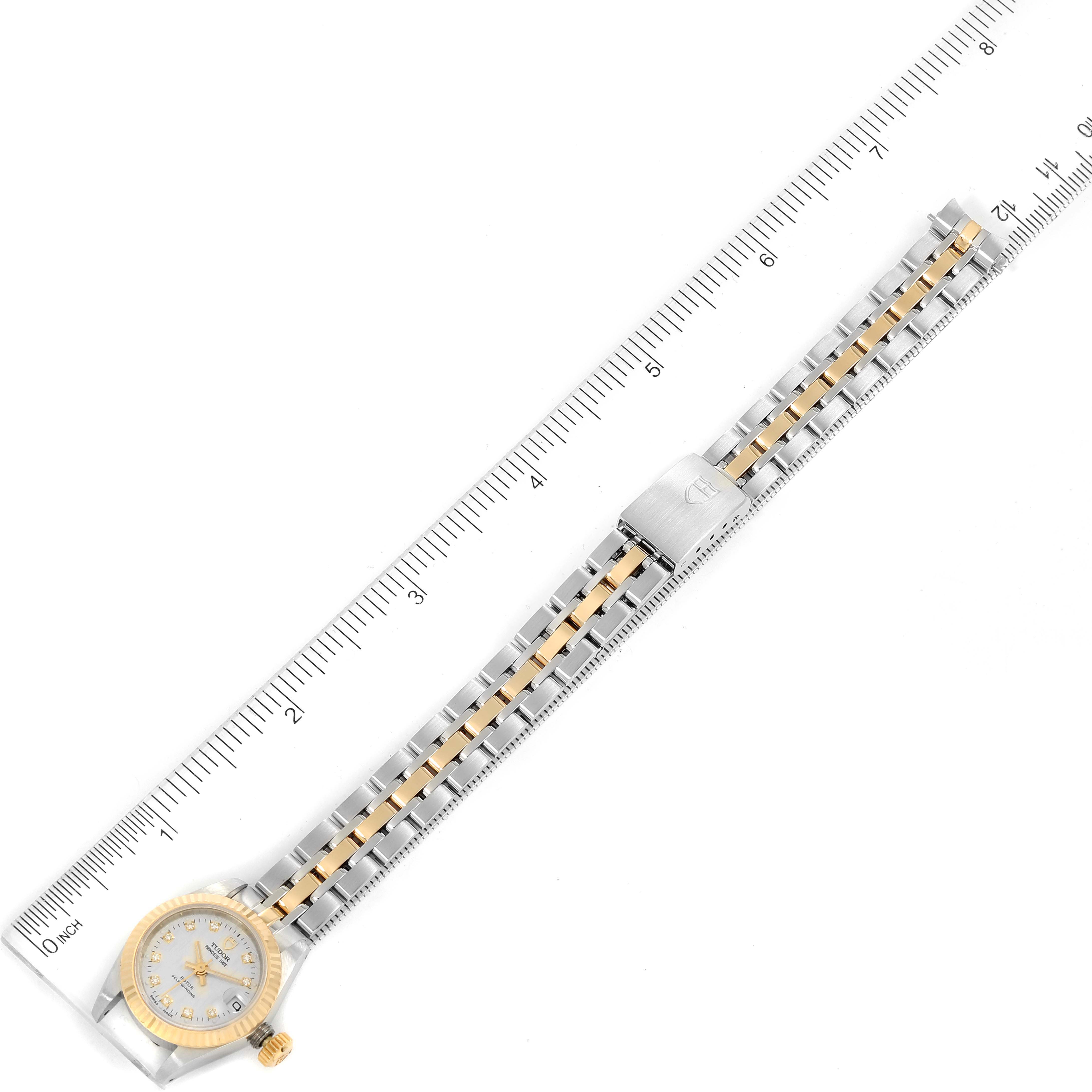 The image shows the Tudor Princess 92513 Women's Steel and Gold (two tone) Silver Dial 92513 Women's Steel and Gold (two tone) Silver Dial model watch laid flat against a ruler, highlighting its face and metal band.