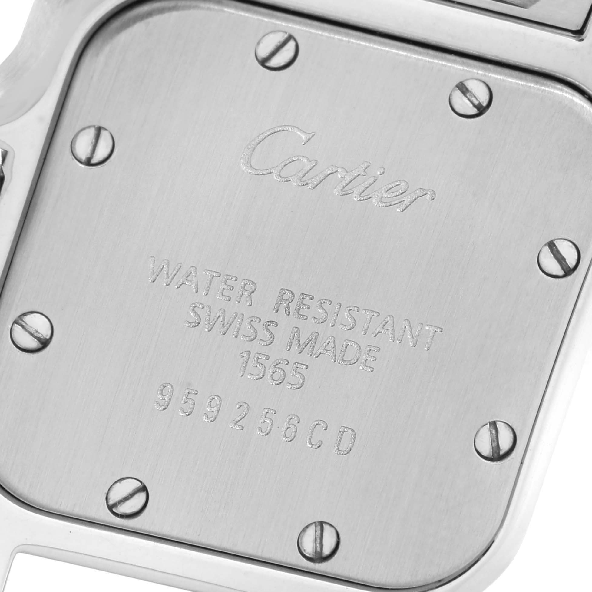 The image shows the back casing of a Santos model watch by Cartier, displaying the engraved brand, water resistance, and serial number.