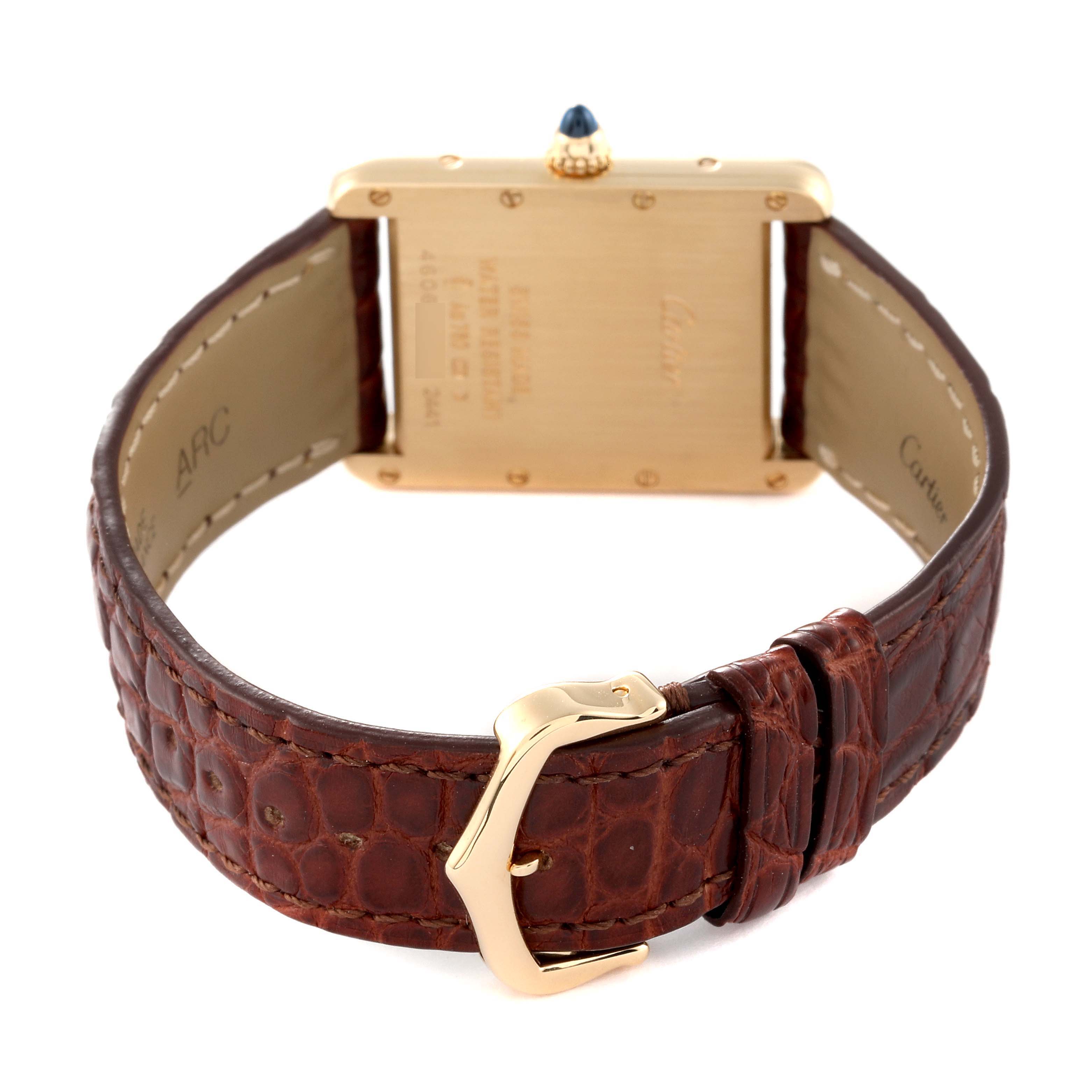 The image shows the back view of the Tank Louis model by Cartier, highlighting the case back, crown, and leather strap with buckle.