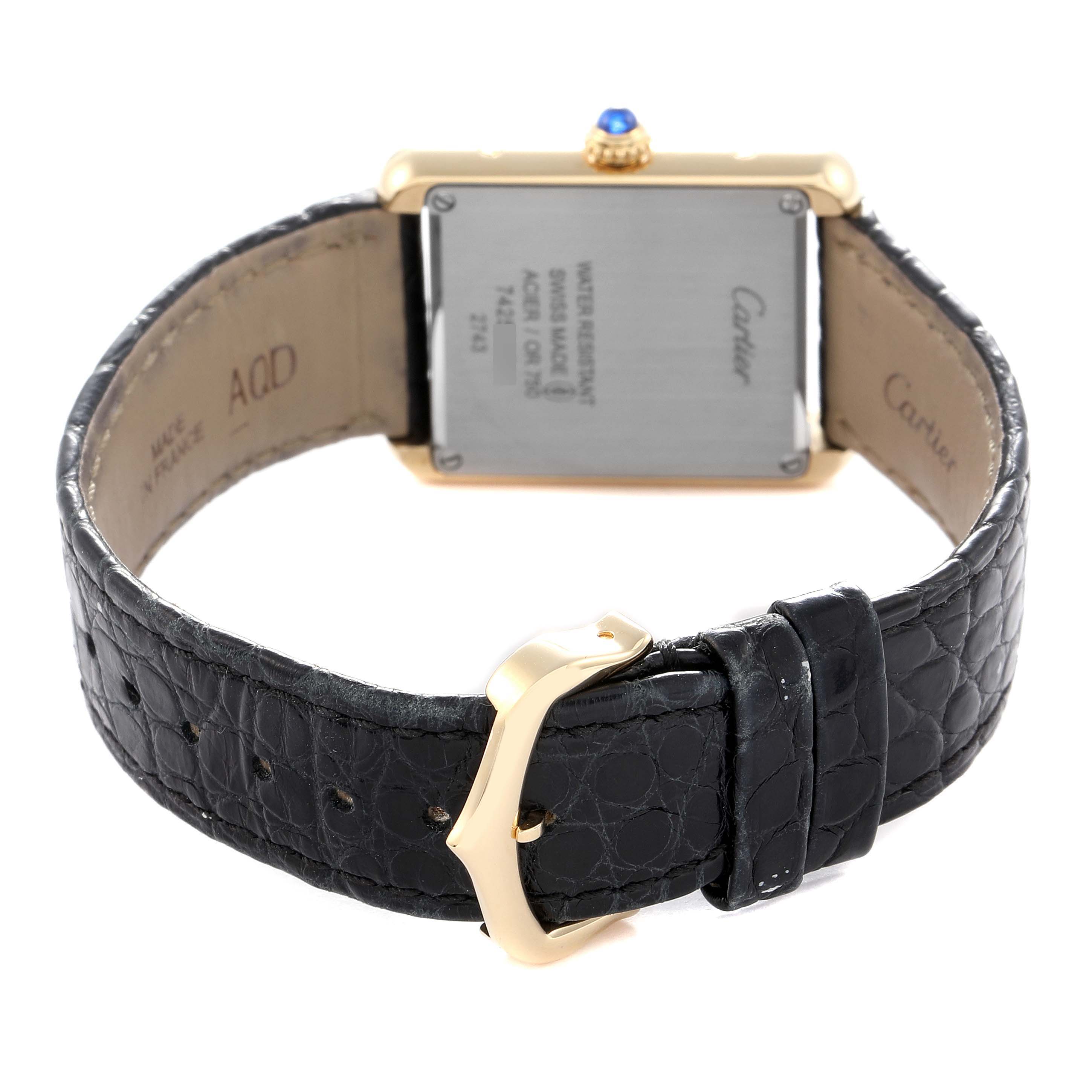 The Cartier Tank Solo W1018755 Women
s Yellow Gold Silver Dial W1018755 Women
s Yellow Gold Silver Dial watch is shown from the back, highlighting the case back, crown, and leather strap with buckle.