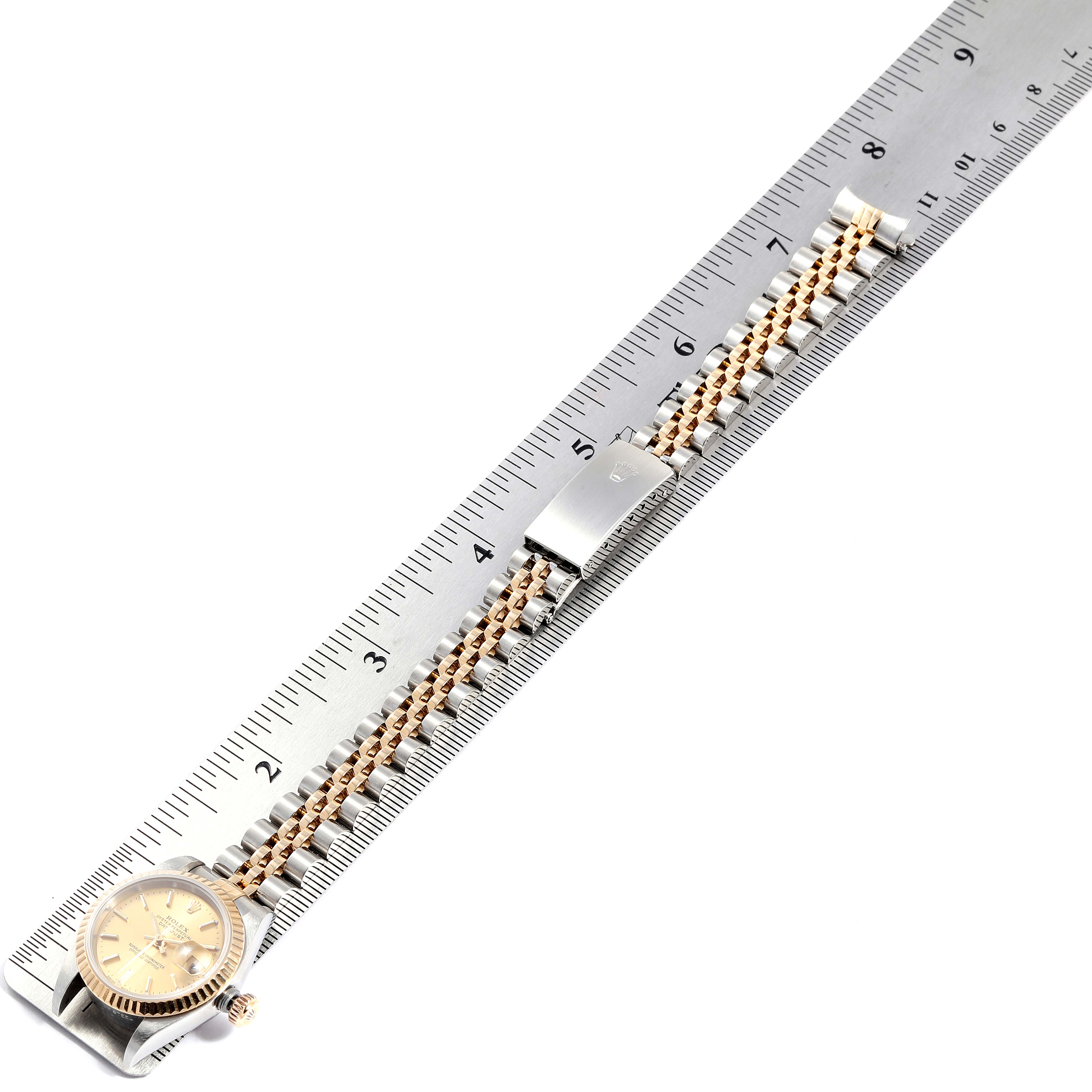 The Rolex Datejust 79173 Women
s Steel and Gold (two tone) Champagne Dial 79173 Women
s Steel and Gold (two tone) Champagne Dial watch is shown from a top-down angle with a ruler measuring its bracelet.