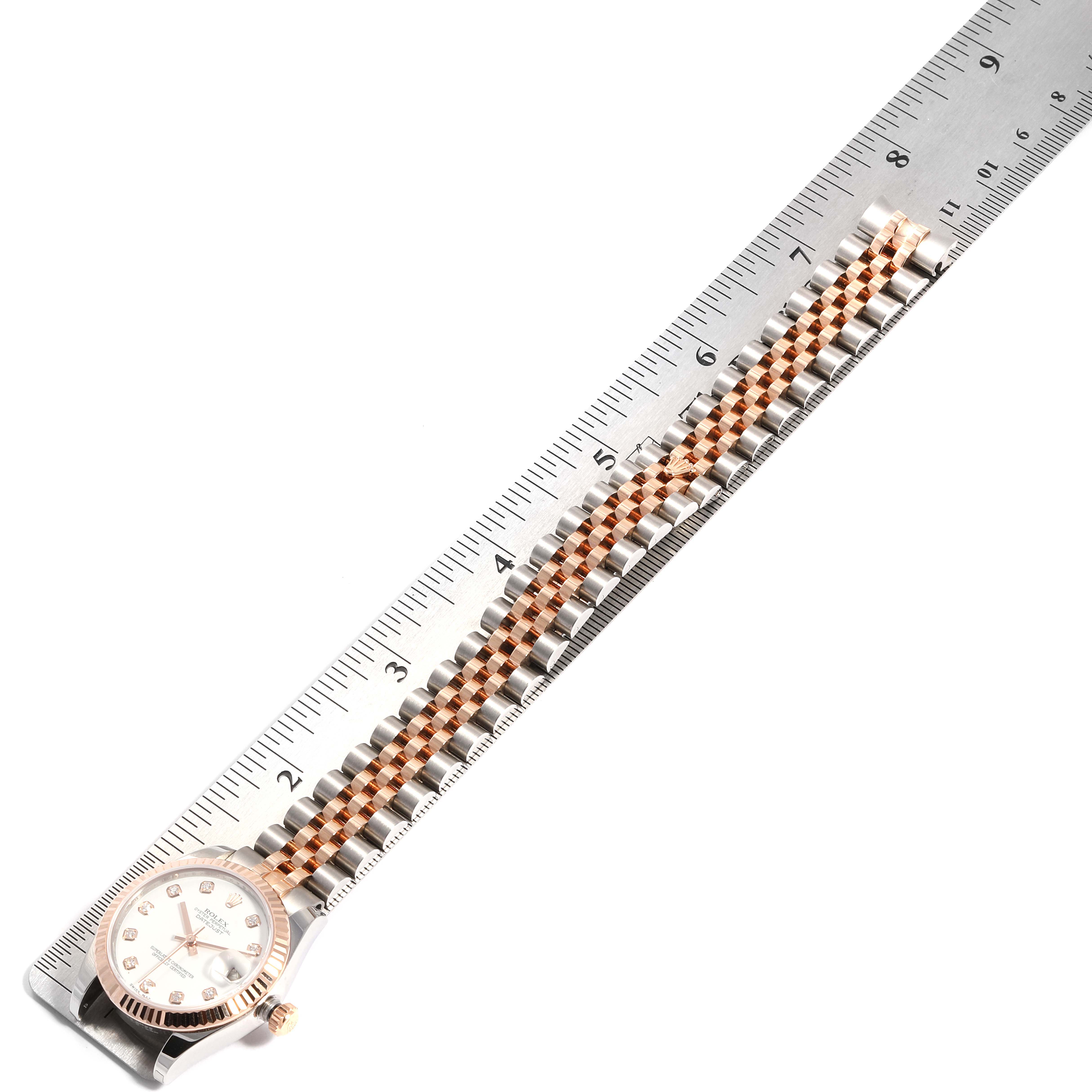The image shows a Mid-Size Rolex watch laid flat next to a ruler, highlighting its band length and design.