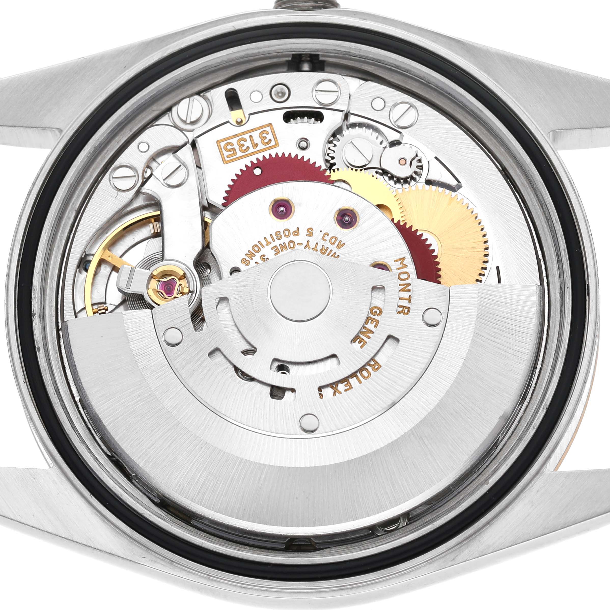 The image shows the intricate movement from the back of a Rolex Datejust 16233 Men's Stainless Steel Champagne Dial watch, featuring gears and mechanical details.