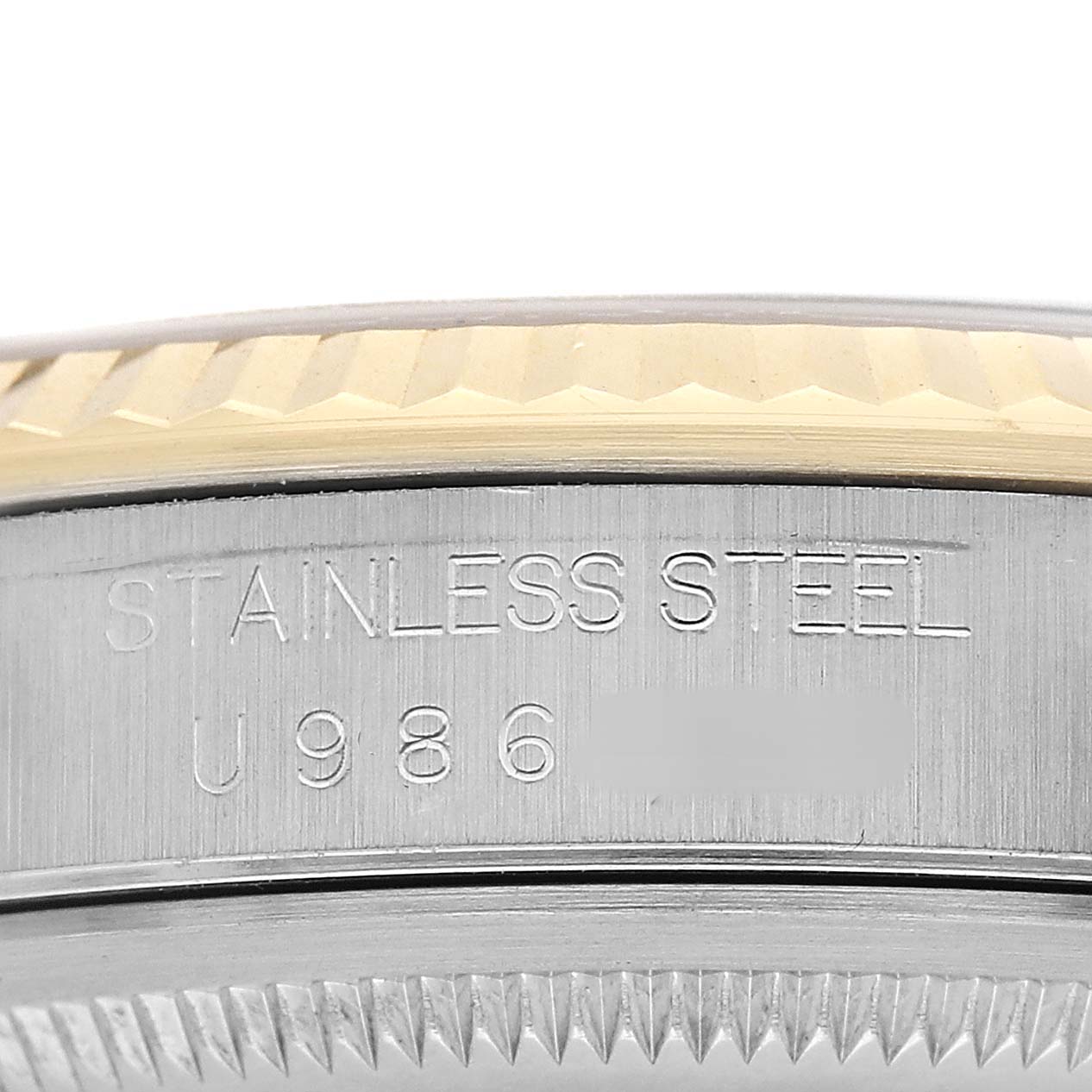 The image shows a close-up of the side of a Rolex Datejust 16233 Men's Stainless Steel Champagne Dial watch, focusing on the engraved case material and part of the fluted bezel.