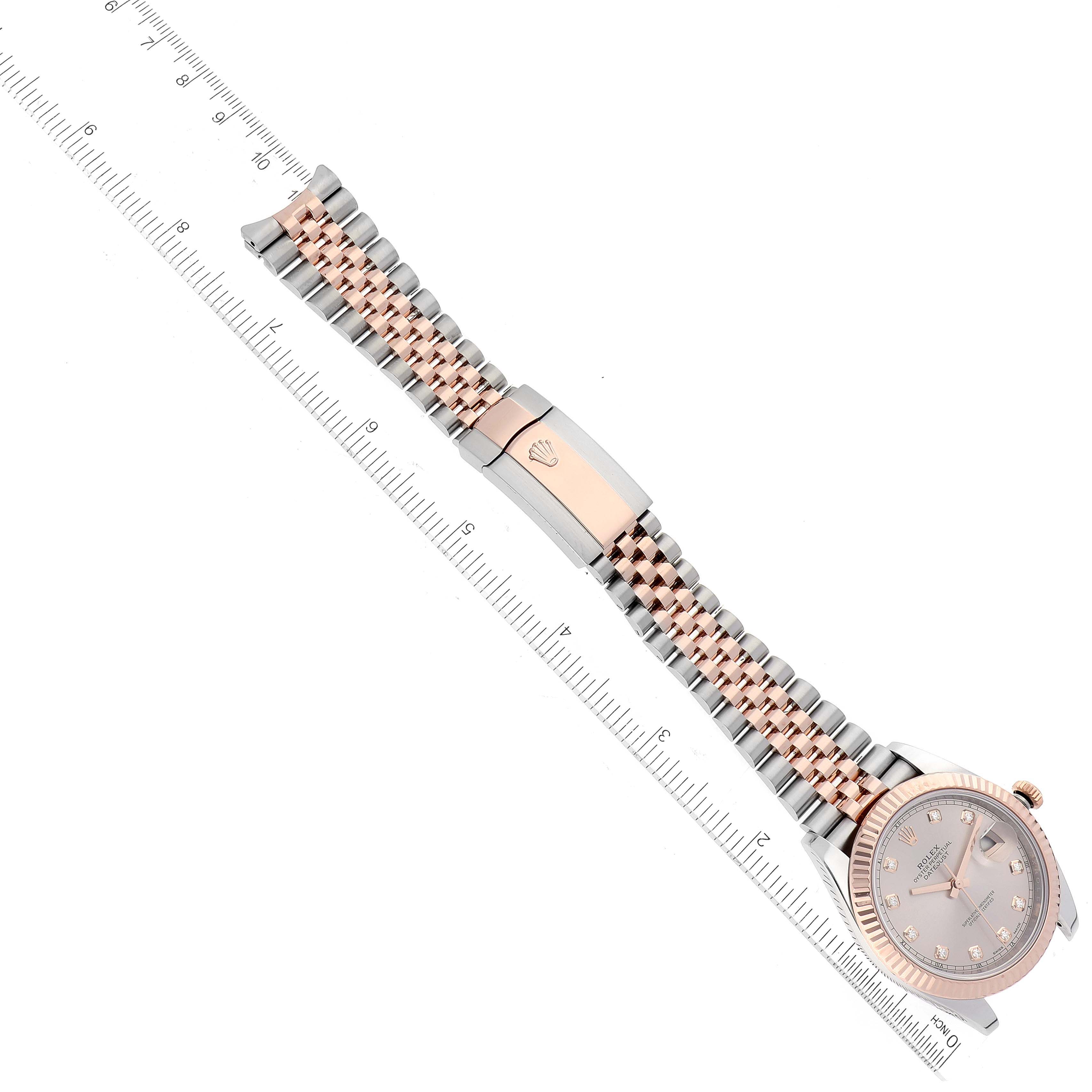 The image shows an aerial view of the Rolex Datejust 41 126331 Men's Steel and Gold (two tone) Pink Dial 126331 Men's Steel and Gold (two tone) Pink Dial watch, displaying its face, bracelet, and clasp with a ruler for scale.