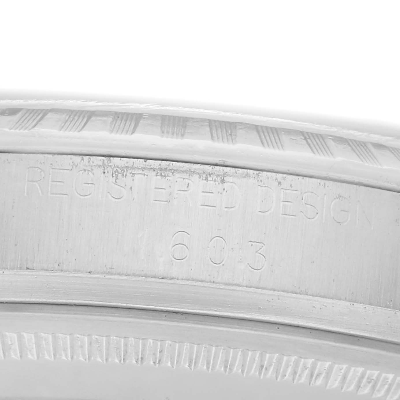 The image shows an angled close-up of the engraving on the side of a Rolex Datejust 1603 Men
s Stainless Steel Silver Dial 1603 Men
s Stainless Steel Silver Dial watch case.
