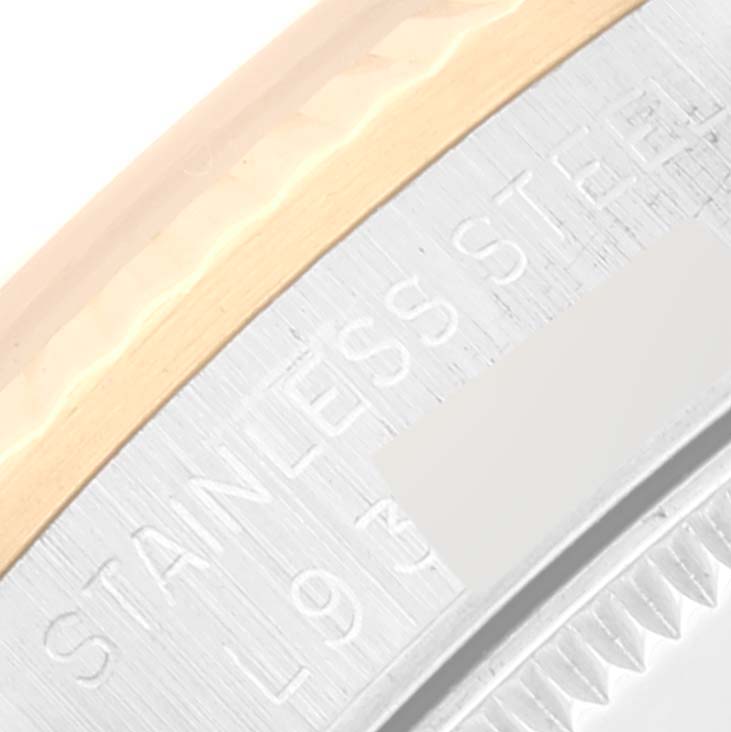 This close-up image of a Rolex Mid-Size 68273 Women's Steel and Gold (two tone) Champagne Dial 68273 Women's Steel and Gold (two tone) Champagne Dial model shows part of the bezel and the inscription on its stainless steel case.