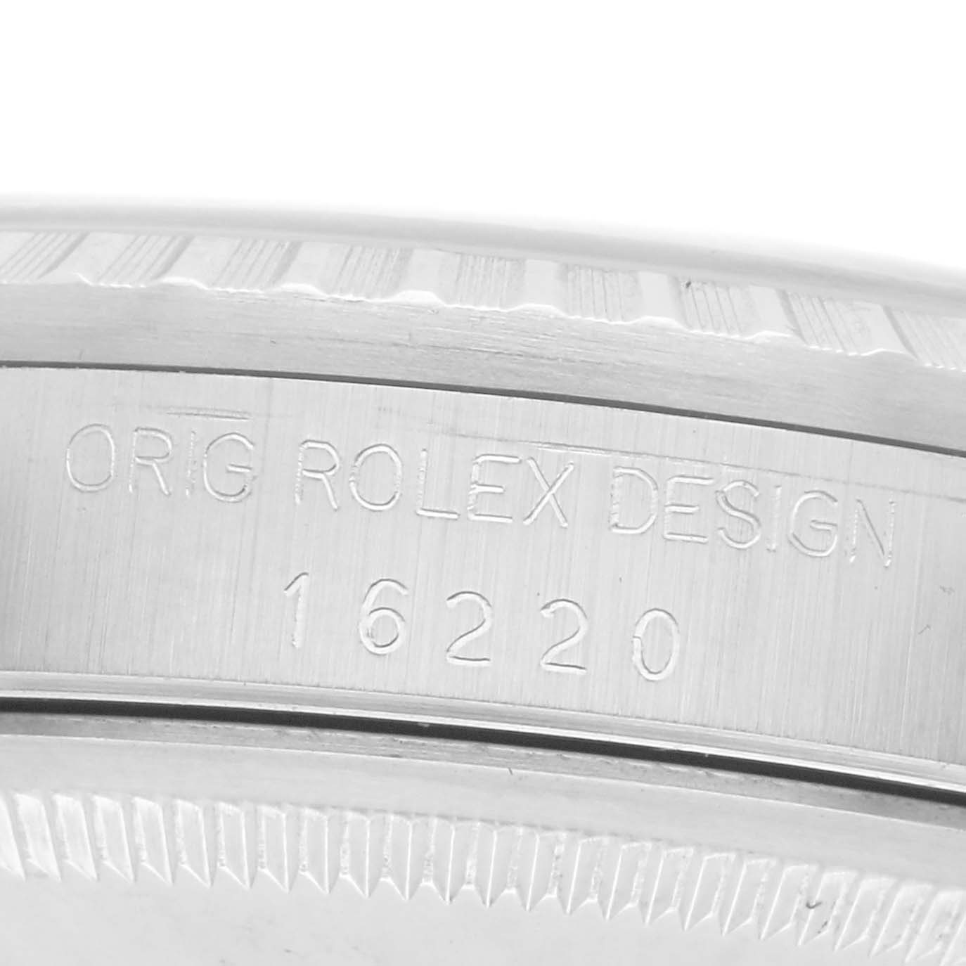 The image shows a close-up of the Rolex Datejust 16220 Men
s Stainless Steel Silver Dial 16220 Men
s Stainless Steel Silver Dial model
s case side, featuring engraved details and part of the bezel.
