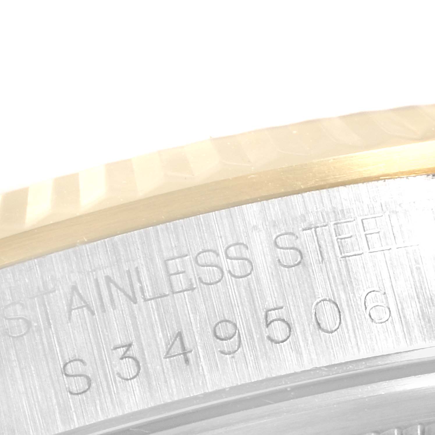 This image shows a close-up of the side case and part of the bezel of a Rolex Datejust 16233 Men
s Steel and Gold (two tone) Champagne Dial 16233 Men
s Steel and Gold (two tone) Champagne Dial watch, highlighting its stainless steel material and serial number.