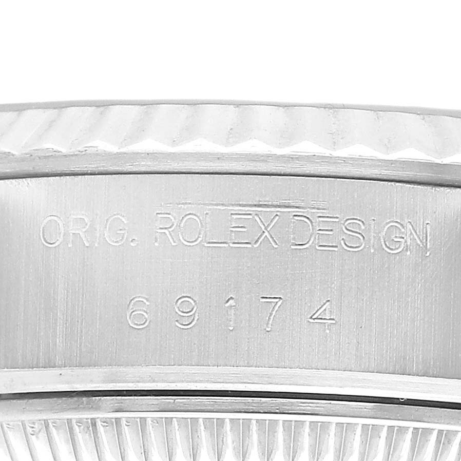 The image shows a close-up of the serial number and part of the bezel on a Rolex Datejust 69174 Women's Stainless Steel Black Dial watch.