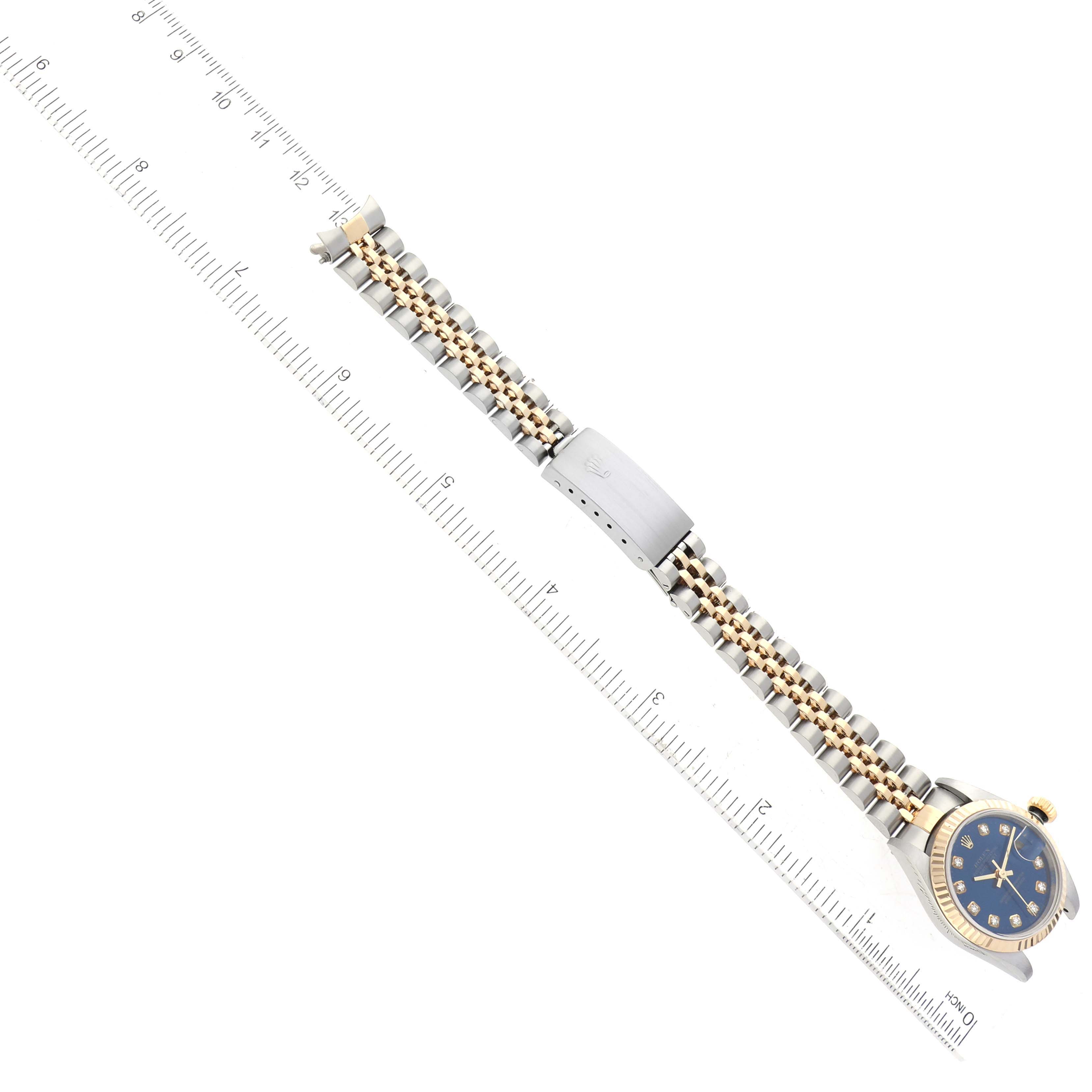 The image shows a Rolex Datejust 79173 Women's Steel and Gold (two tone) Blue Dial 79173 Women's Steel and Gold (two tone) Blue Dial watch laid flat with a full view of the bracelet and a partial view of the face, next to a ruler for scale.