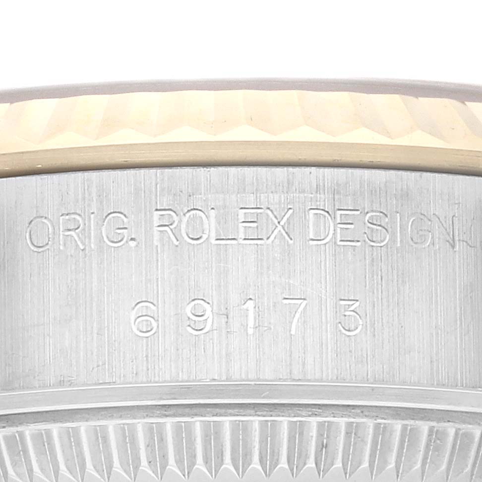 The image shows a close-up of the side of a Rolex Datejust 69173G Women's Steel and Gold (two tone) Champagne Dial 69173G Women's Steel and Gold (two tone) Champagne Dial watch, highlighting its engraved design and model number.