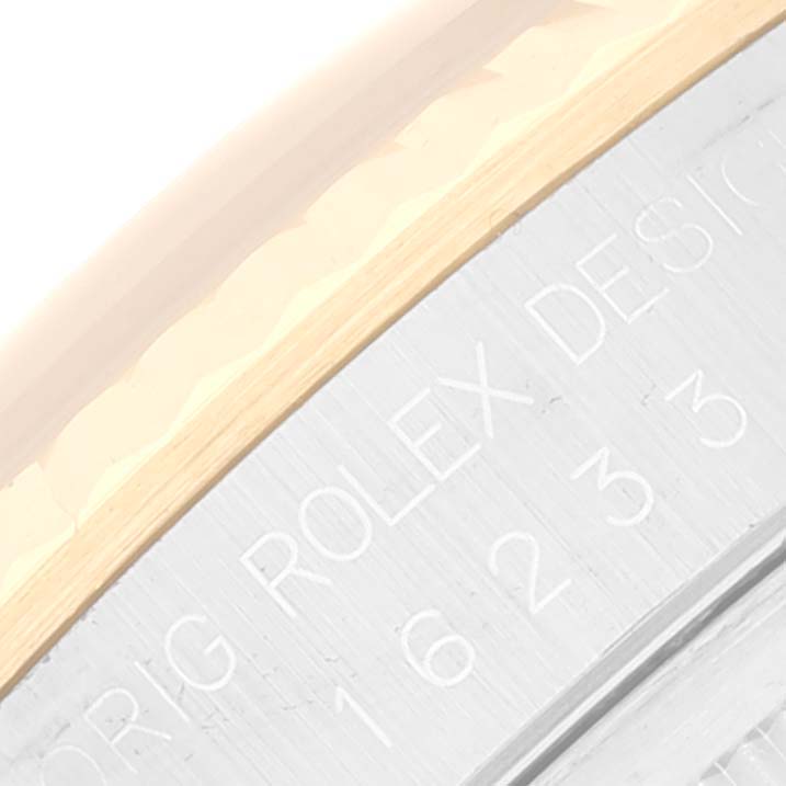 This image shows a close-up of the engraved bezel and part of the fluted edge of a Rolex Datejust 16233 Men's Steel and Gold (two tone) Grey Dial 16233 Men's Steel and Gold (two tone) Grey Dial watch.