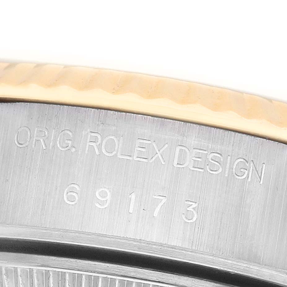 The image shows a close-up of the side of a Rolex Datejust 69173 Women's Steel and Gold (two tone) White Dial, highlighting its engraved model number and design details.