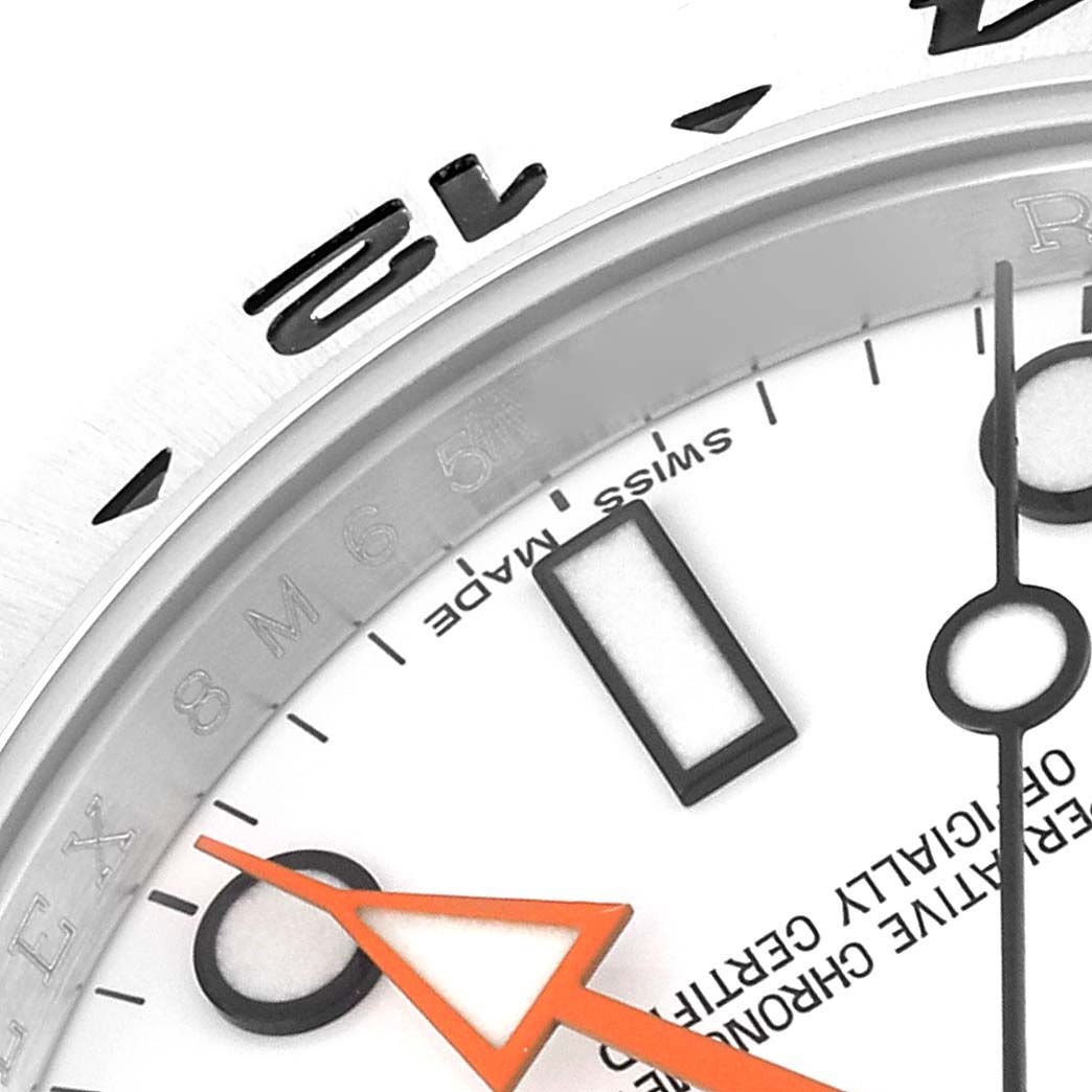 This close-up view of the Rolex Explorer 216570 Men
s Stainless Steel White Dial 216570 Men
s Stainless Steel White Dial watch shows part of the dial, orange hand, and partial bezel.