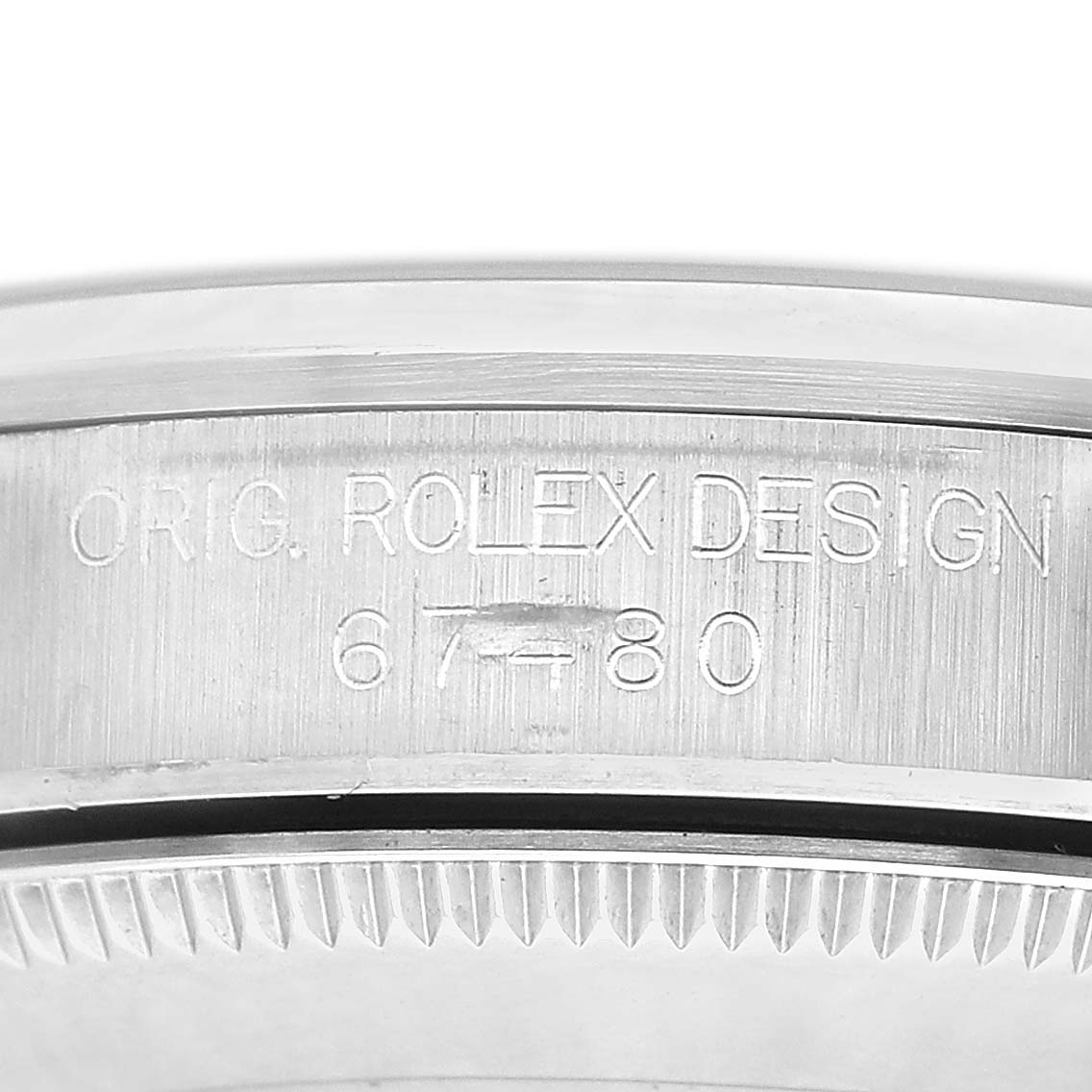 The image shows the side view of a Rolex Mid-Size 67480 Women's Stainless Steel Blue Dial model, focusing on the engraved details of the bezel and case edge.