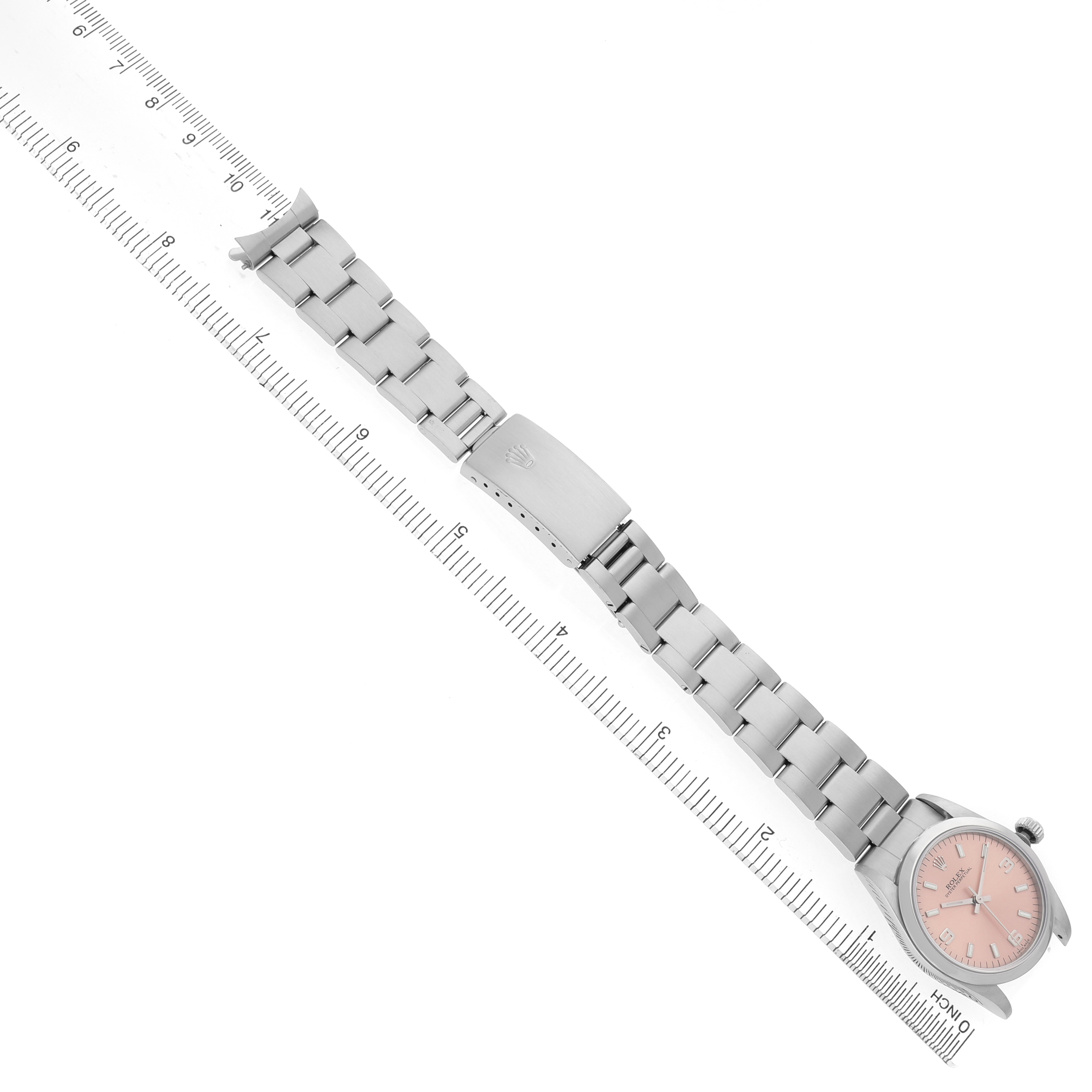 The image shows a Rolex Mid-Size 67480 Women's Stainless Steel Pink Dial watch from an angled top view, featuring the bracelet and clasp, alongside a ruler for scale.