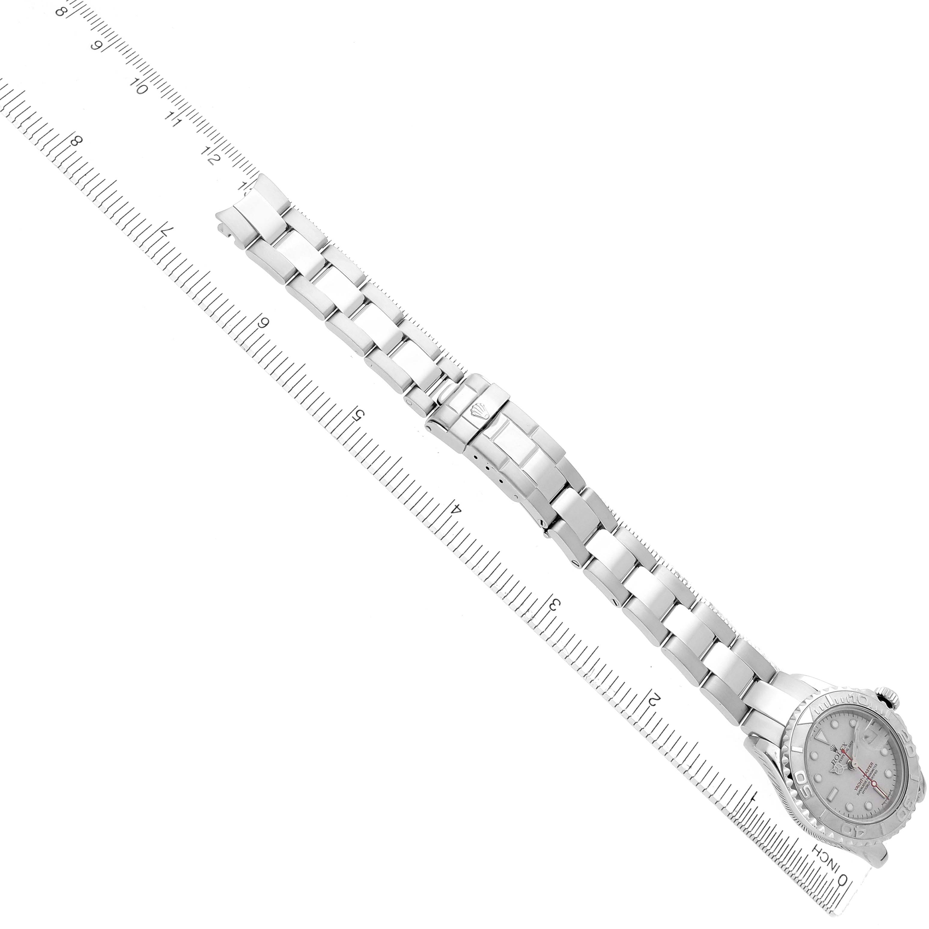 The Rolex Yacht-Master 169622 Women's Stainless Steel Silver Dial watch is displayed from a top-down angle, showing the full bracelet and clasp next to a measuring scale.