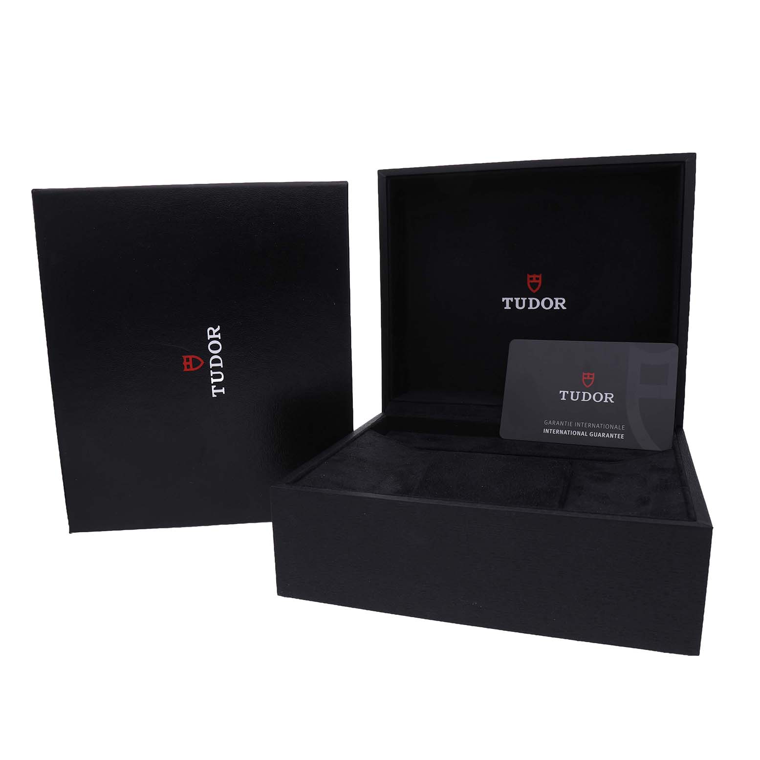 The Tudor Heritage Chrono 79360N Men's Stainless Steel Blue Dial watch accessories include an open black box and an international guarantee card, seen from an angled view.
