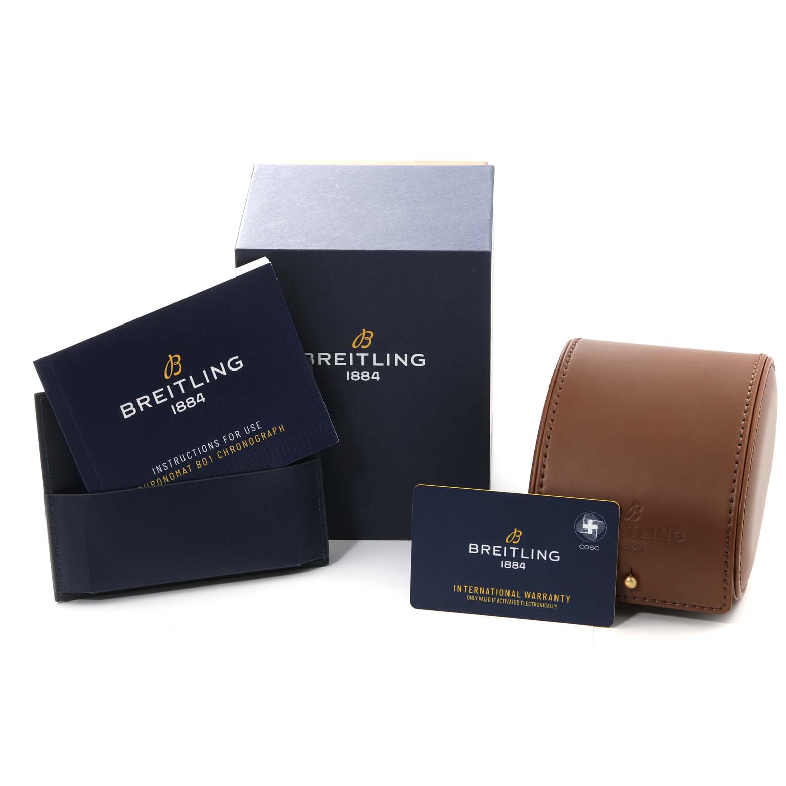 The image shows a Breitling Chronomat IB0134 Men
s Stainless Steel Silver Dial IB0134 Men
s Stainless Steel Silver Dial watch box, a leather case, an instruction manual, and an international warranty card.