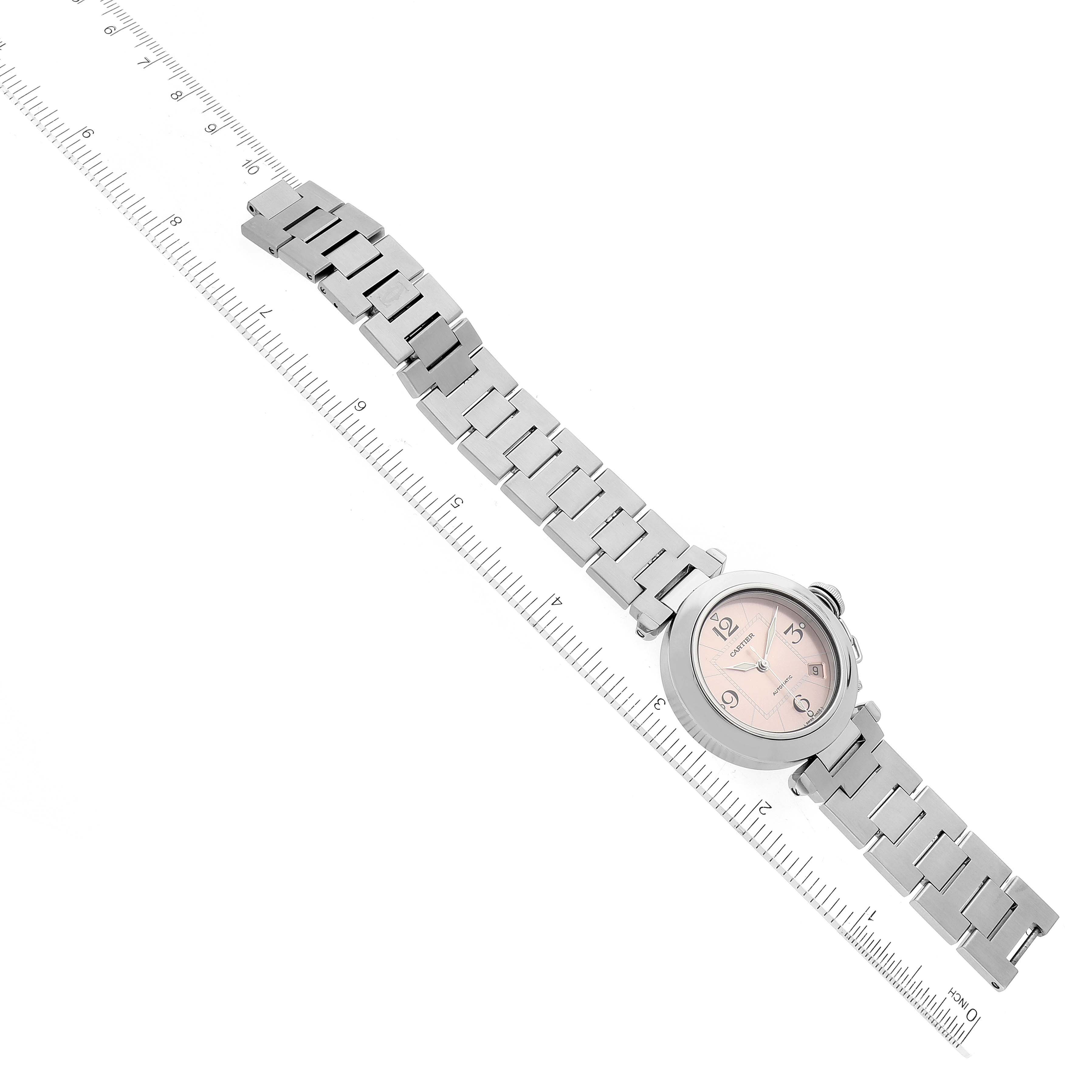 The Cartier Pasha W31075M7 Women's Stainless Steel Pink Dial W31075M7 Women's Stainless Steel Pink Dial watch is shown at a top-down angle with a visible ruler for size reference.