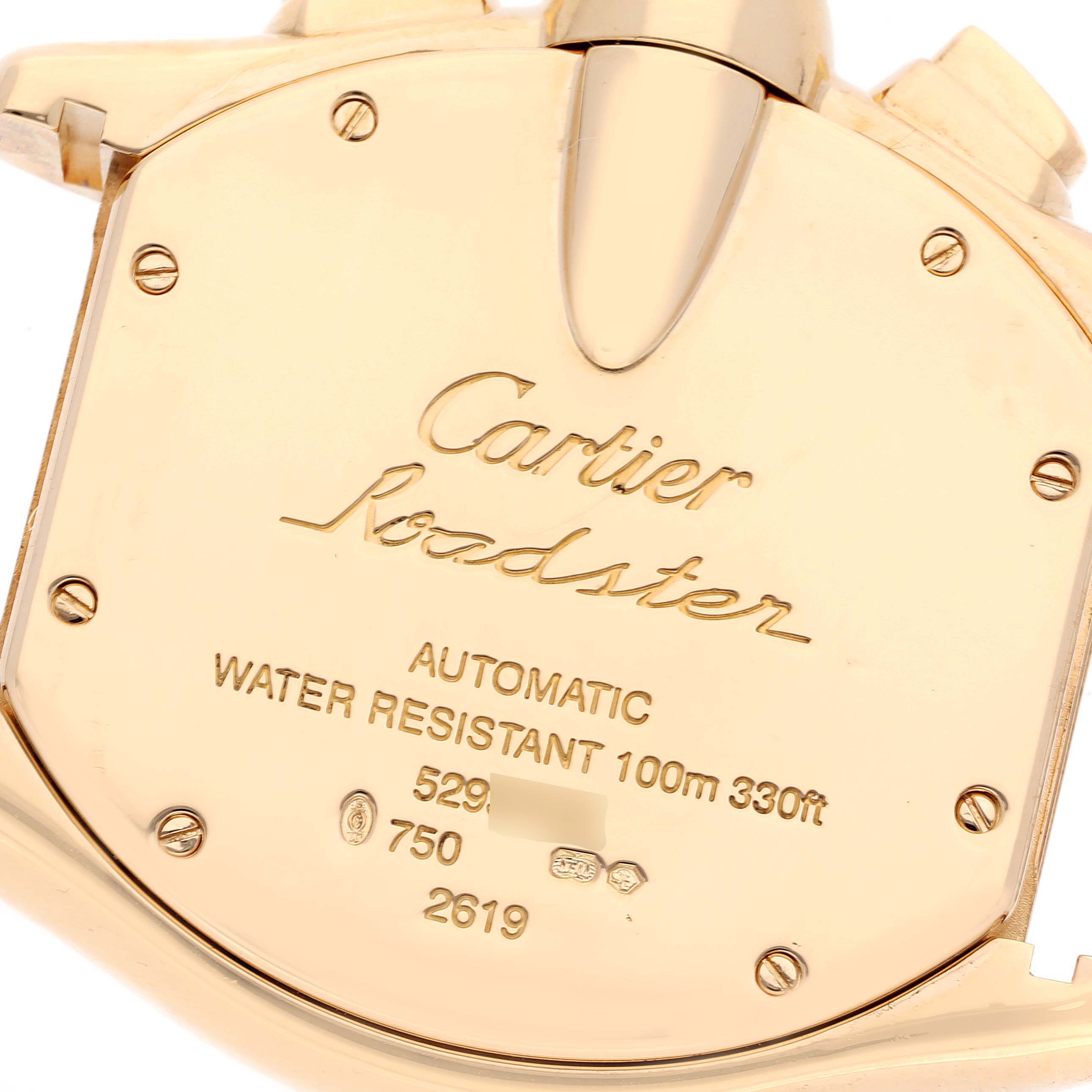 The image shows the yellow-gold back case of a Cartier Roadster W62021Y3 Men's Yellow Gold Champagne Dial W62021Y3 Men's Yellow Gold Champagne Dial watch, displaying details like water resistance and certification marks.