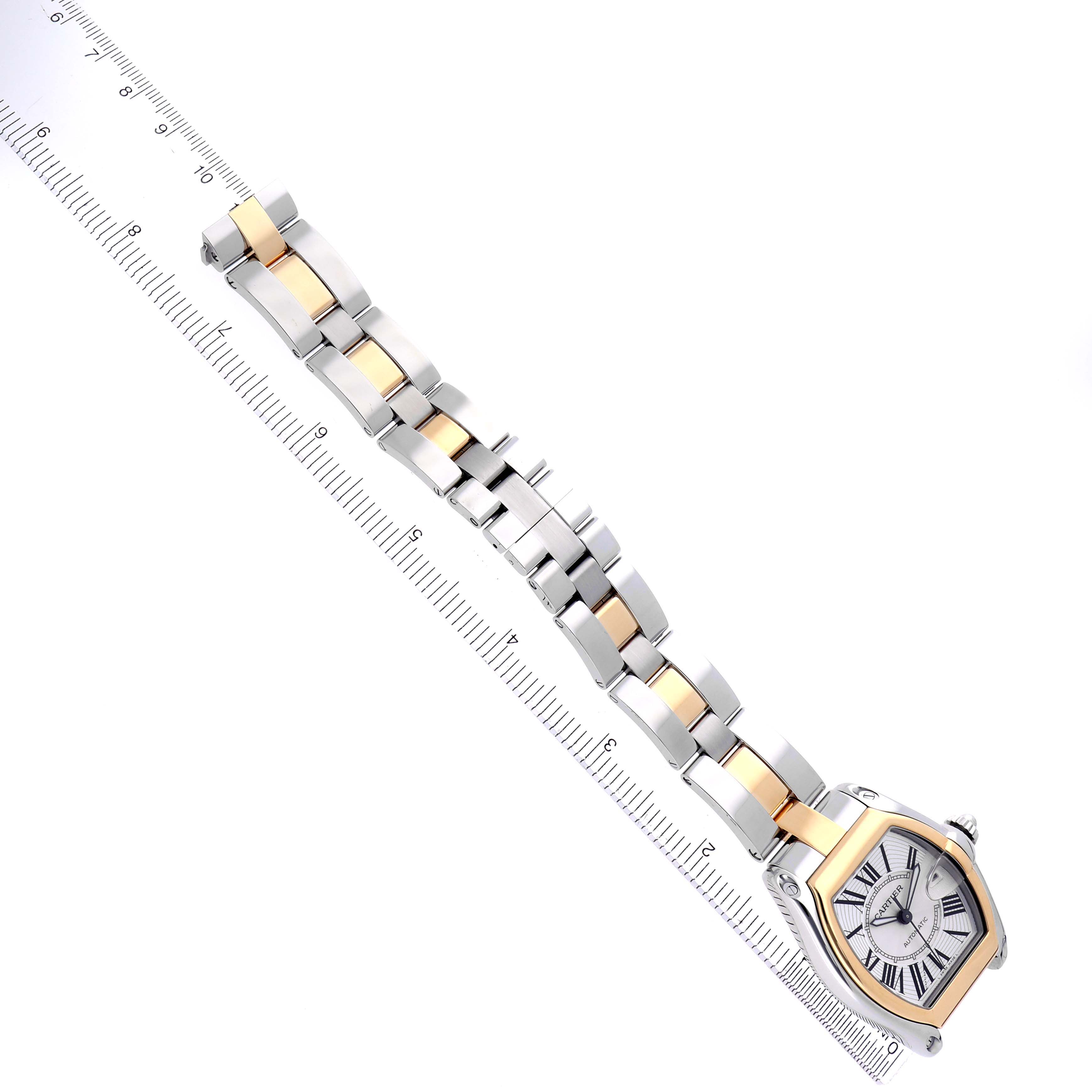The Cartier Roadster model W62031Y4 men
s watch is shown at a diagonal angle, highlighting its two-tone bracelet and face alongside a measuring ruler.