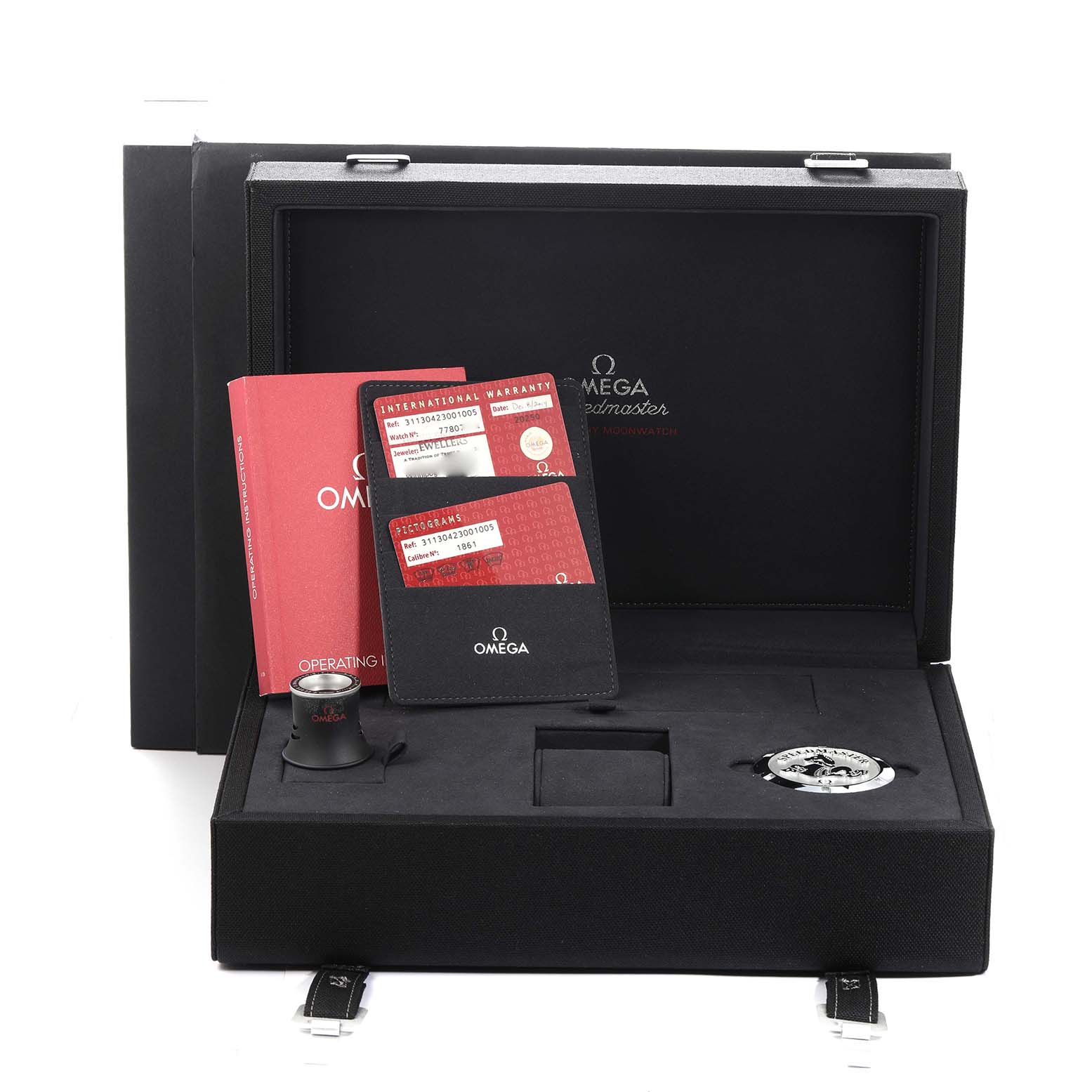 The image shows the packaging and accessories for the Omega Speedmaster model 311.30.42.30.01.005, including a manual, warranty cards, loupe, and strap in a box.