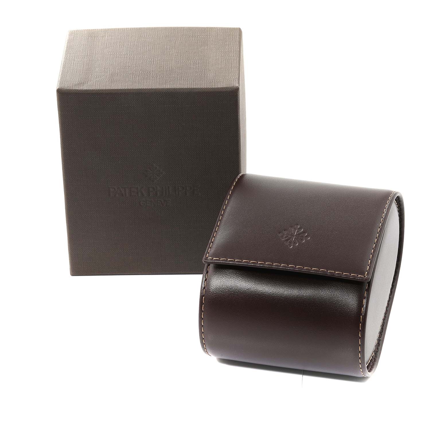 This image shows the packaging for a Patek Philippe Gondolo 5024/1J-001 Men's Yellow Gold White Dial 5024/1J-001 Men's Yellow Gold White Dial watch, including a brown leather case and a branded box.