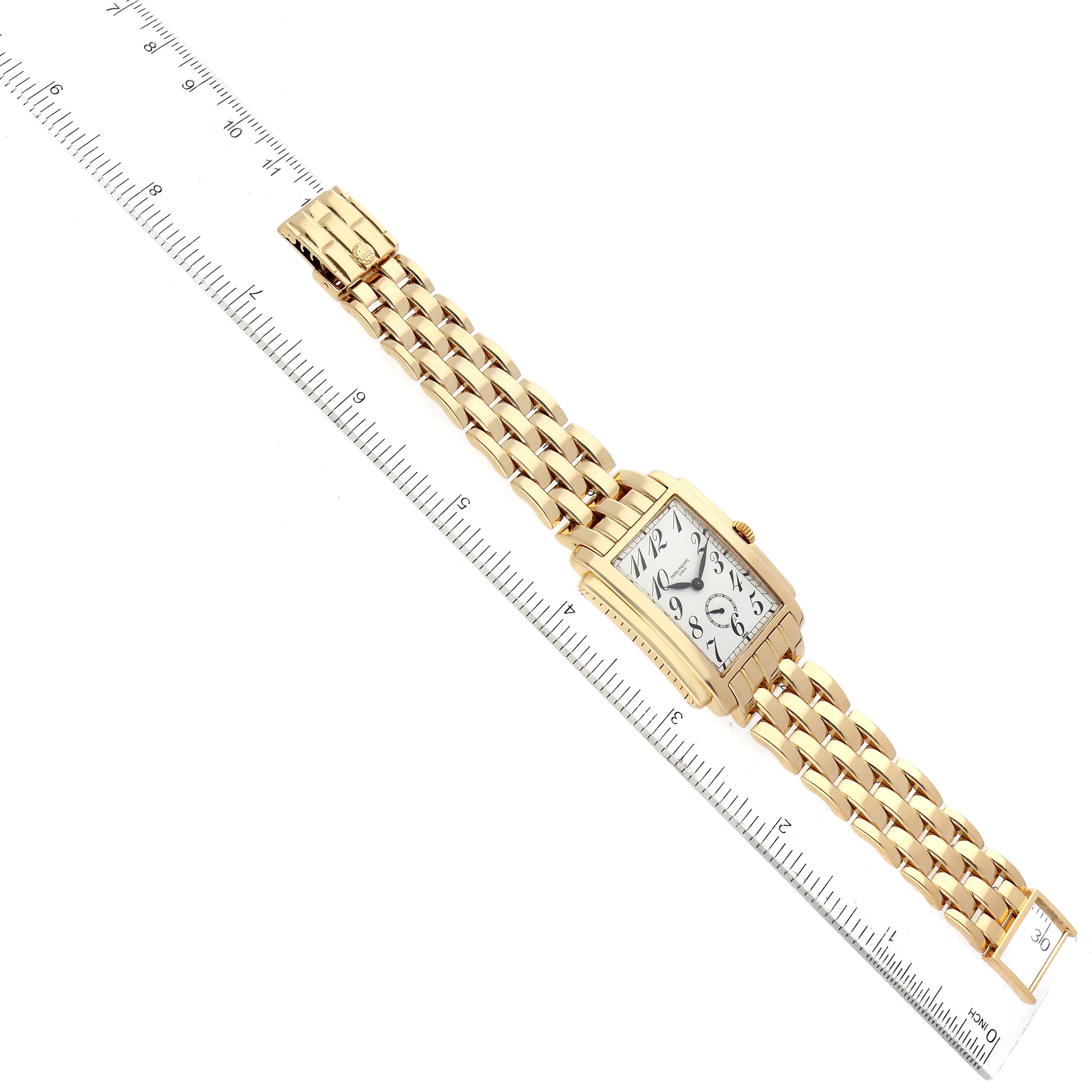 The image shows a gold Patek Philippe Gondolo 5024/1J-001 Men's Yellow Gold White Dial 5024/1J-001 Men's Yellow Gold White Dial watch lying flat, displaying the full bracelet and face, alongside a measuring ruler.