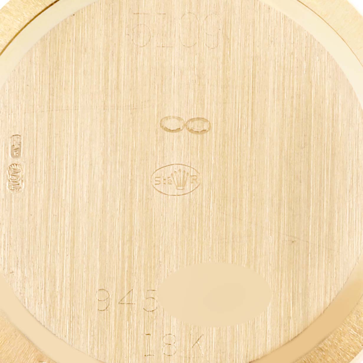 This image shows the engraved details on the back case of a Rolex Cellini 5109 Women's Yellow Gold White Dial 5109 Women's Yellow Gold White Dial watch, highlighting the material and branding.