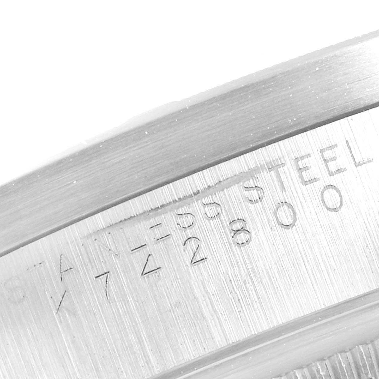 The image shows a close-up of the side of the Rolex Date 15210 Men's Stainless Steel Black Dial 15210 Men's Stainless Steel Black Dial model, highlighting the serial number and "STAINLESS STEEL" engraving.