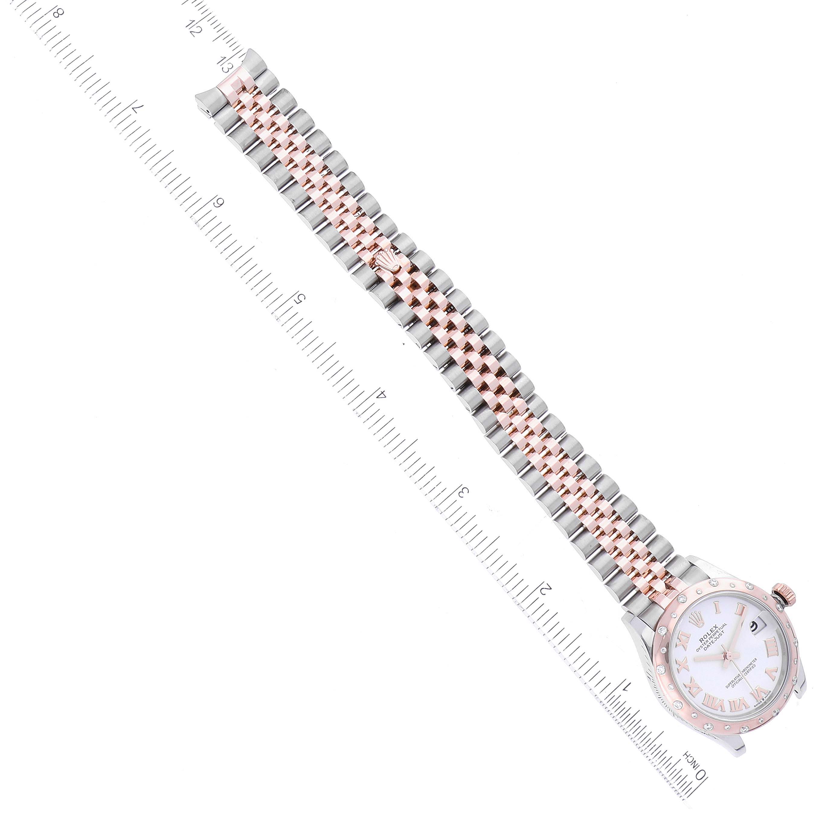 This image shows a top-down view of a Rolex Mid-Size 278341 Women's Steel and Gold (two tone) White Dial 278341 Women's Steel and Gold (two tone) White Dial watch with a white face and a two-tone metal bracelet next to a ruler.