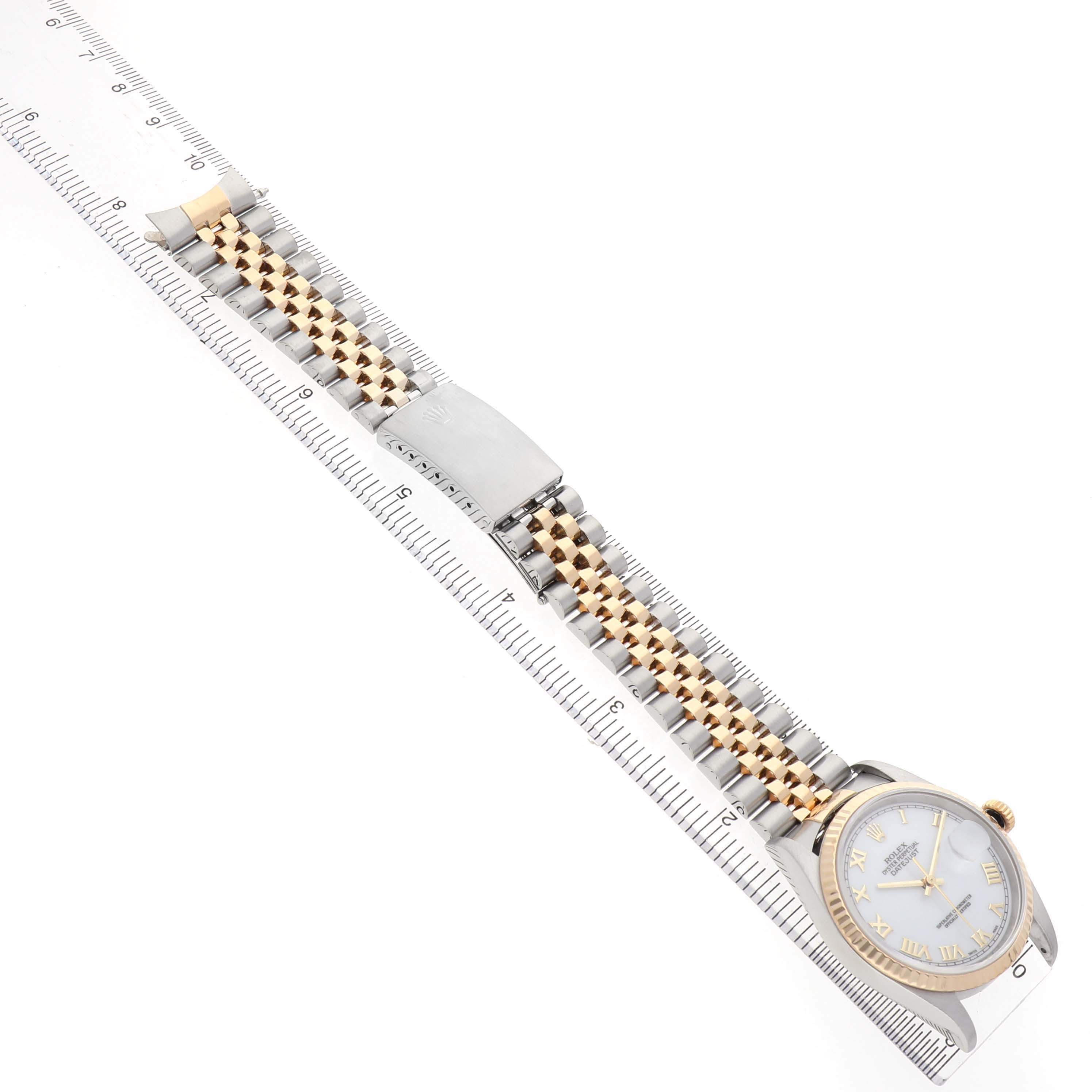 The Rolex Datejust 16233 Men's Steel and Gold (two tone) White Dial watch is shown diagonally, highlighting the case, dial, and two-tone bracelet alongside a measuring ruler.