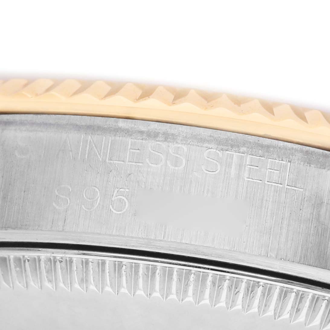 The image shows a close-up of the edge and bezel of a Rolex Mid-Size 68273 Women's Steel and Gold (two tone) Champagne Dial watch, highlighting its two-tone metal and engraved details.
