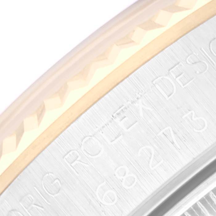 This close-up image shows part of the bezel and casing of a Mid-Size Rolex watch.